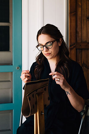 Megan saddle stitching a leather bag in the Stitch &amp; Shutter Studio 