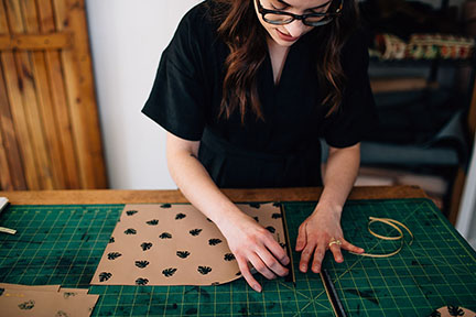 Megan placing a zipper on a leather bag in the Stitch &amp; Shutter Studio 