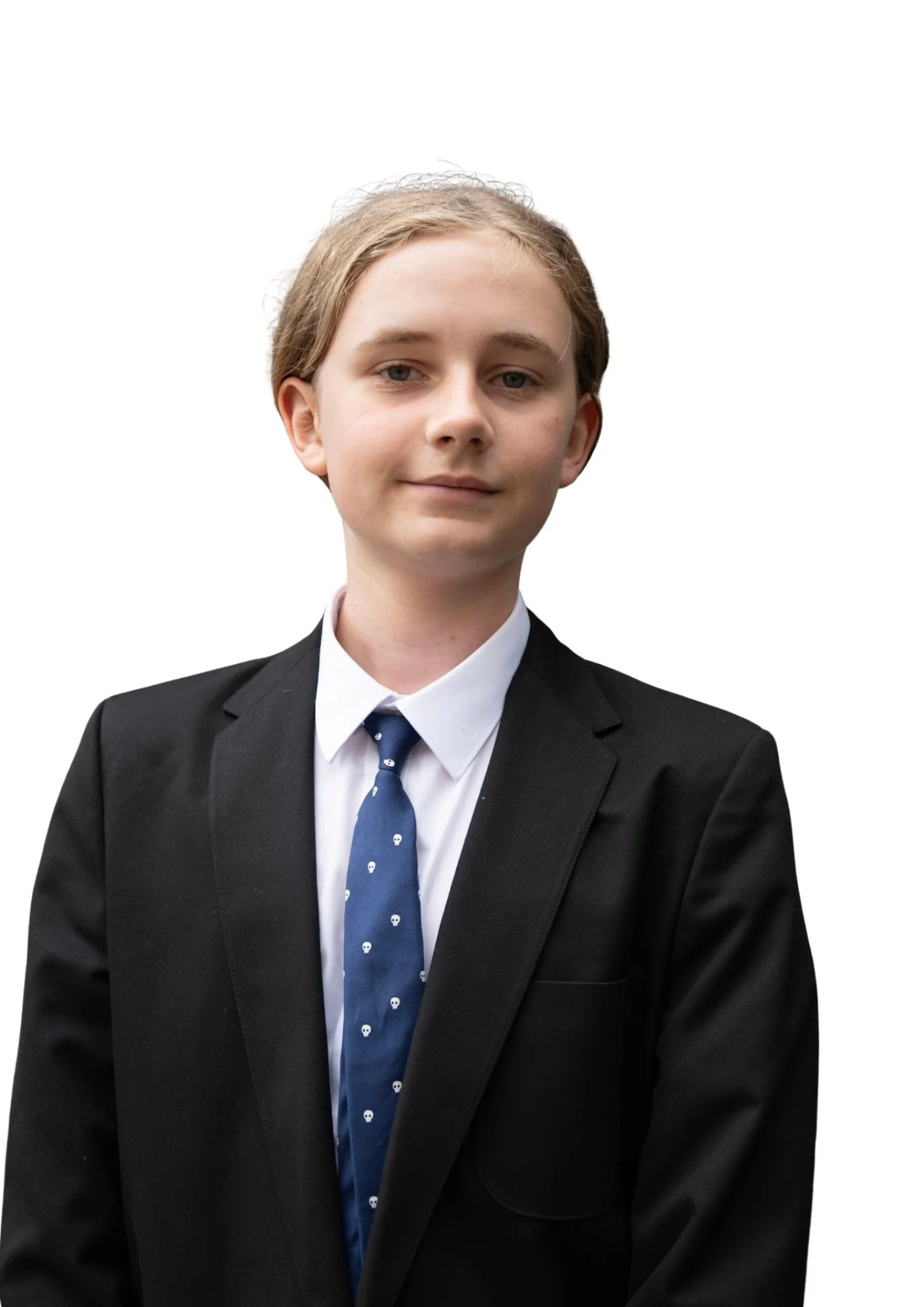 Portrait of a young man wearing a black suit, white shirt, and blue tie with small white skull patterns, against a plain white background.