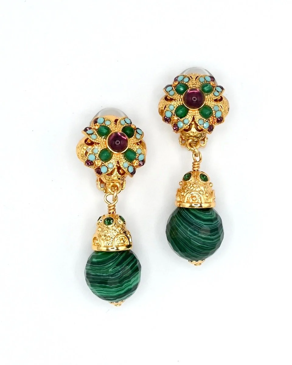 Gold earrings with intricate design, featuring green, purple, and blue stones, with a large green striped bead hanging at the bottom.