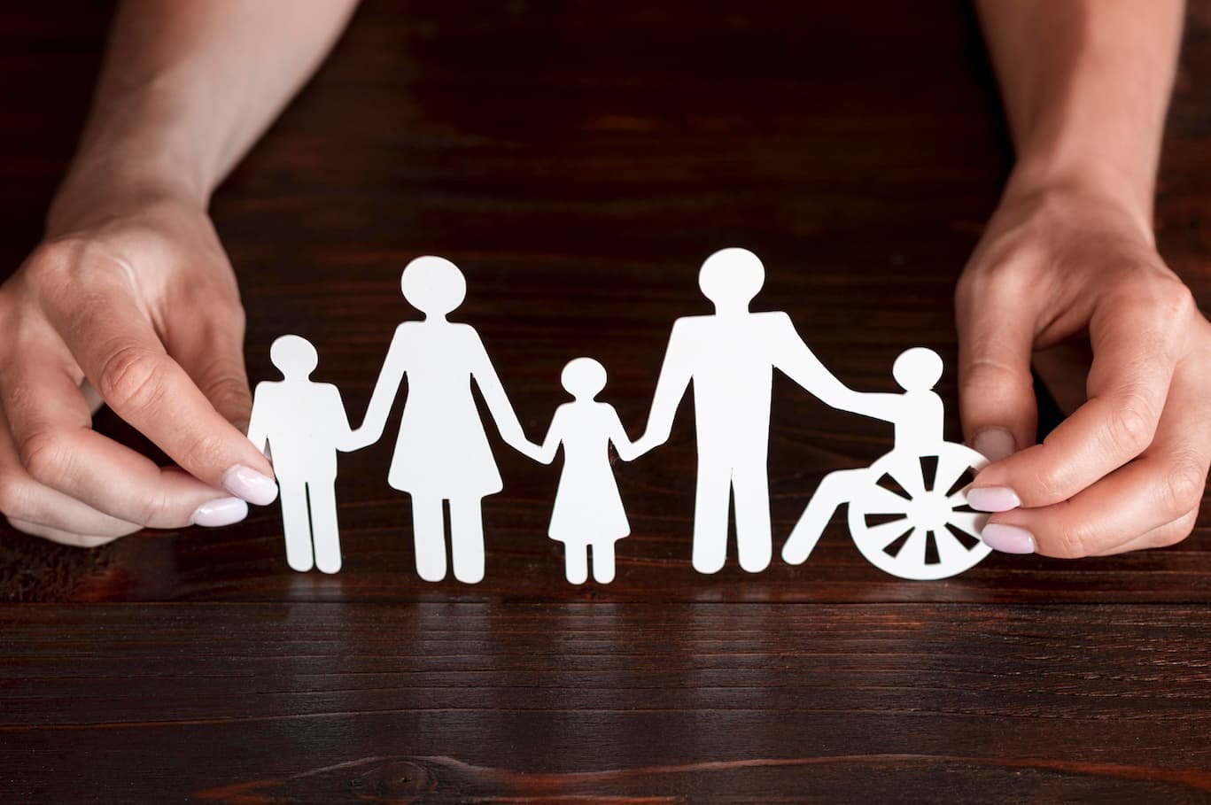Picture of a paper cut out in the shape of the silhouettes of able adults, children and a person in a wheelchair