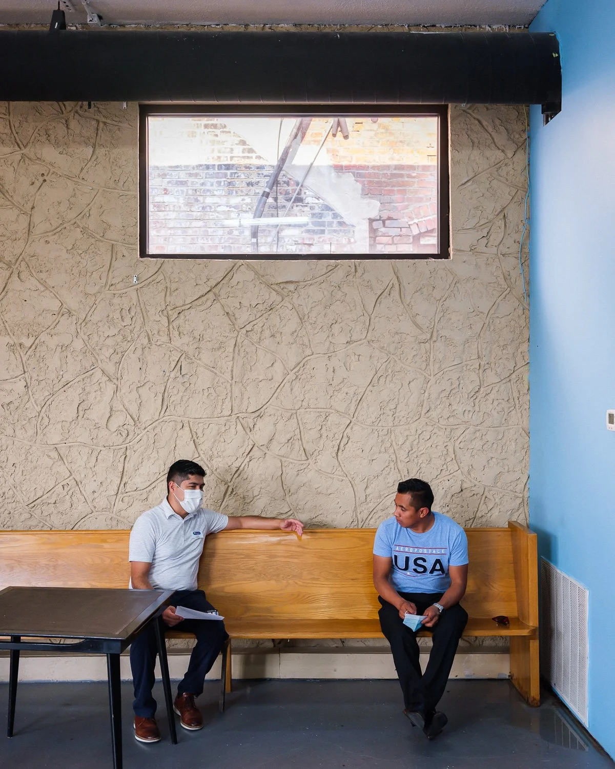 Pharmacist Jose Guerrero speaks with client Juan Matul, 35, at Edgar's Barber Shop to recruit for a COVID vaccine trial, Grand Island, NE, for The New York Times, 2020 