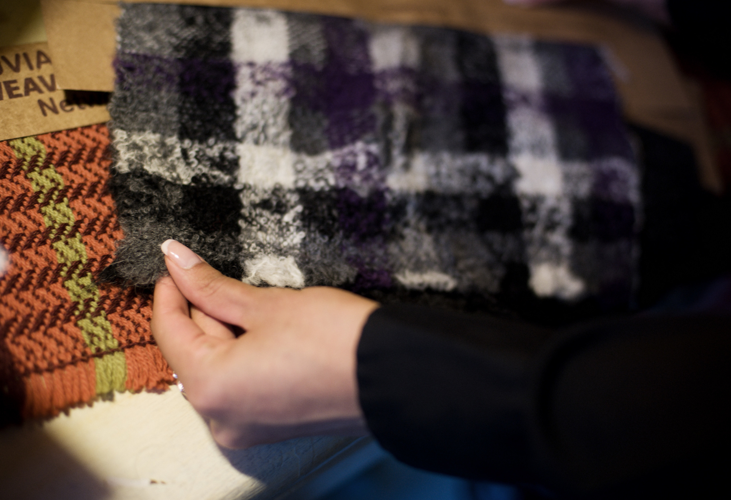  Benita tests the hand of one of the Peruvian textiles recently brought back from a sourcing trip. 