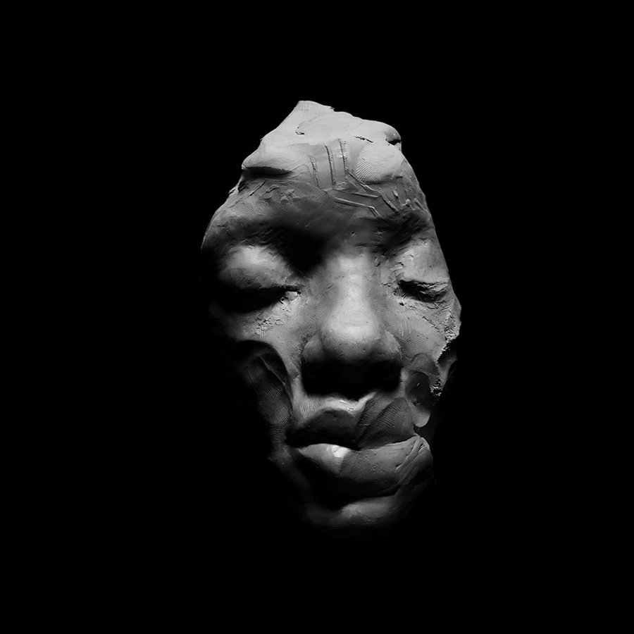 A black and white sculpture of a face with closed eyes, partially covered in darkness.