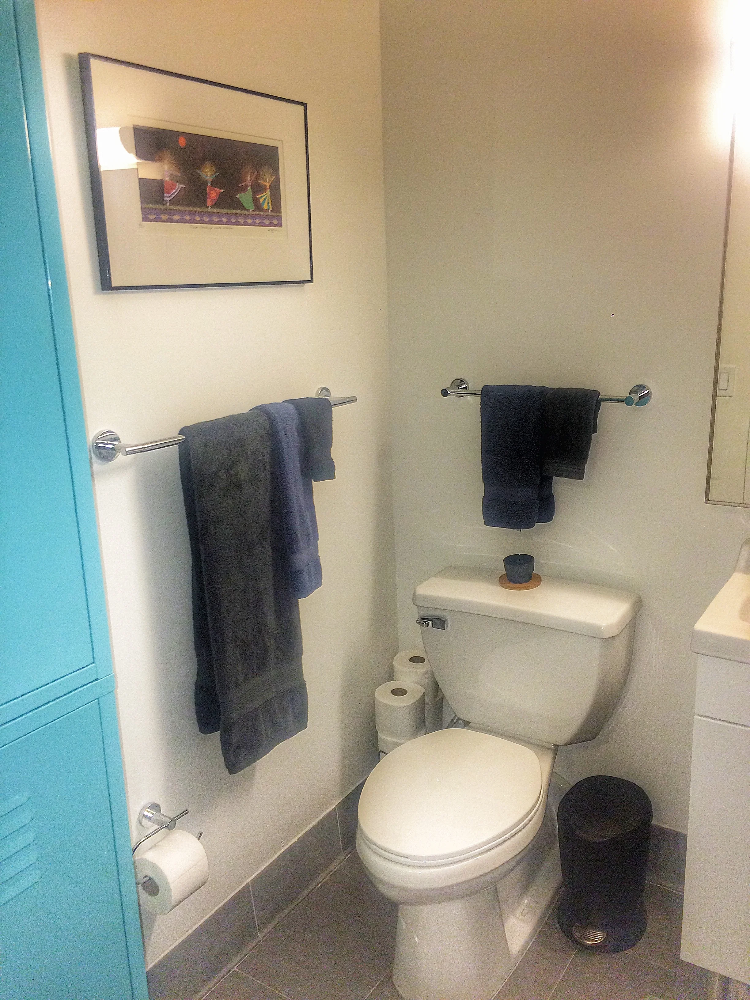 A tall locker is added to the spacious bathroom to hold towels and toiletries to keep the space clean and functional.