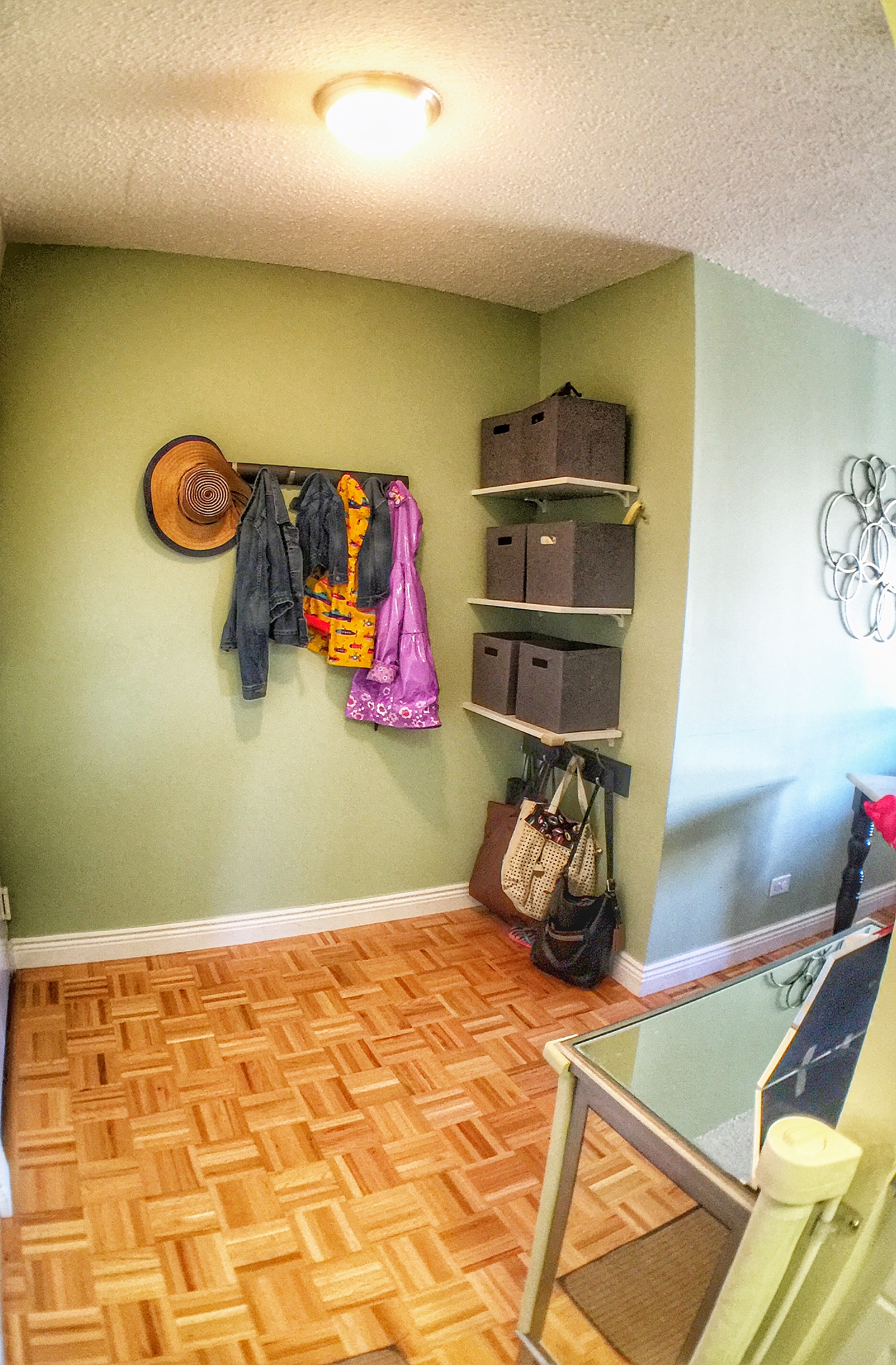 This entry way received shelves with personal bins for each of the family members. The family stroller now has enough room to store right under the bottom shelf without blocking the door. 
