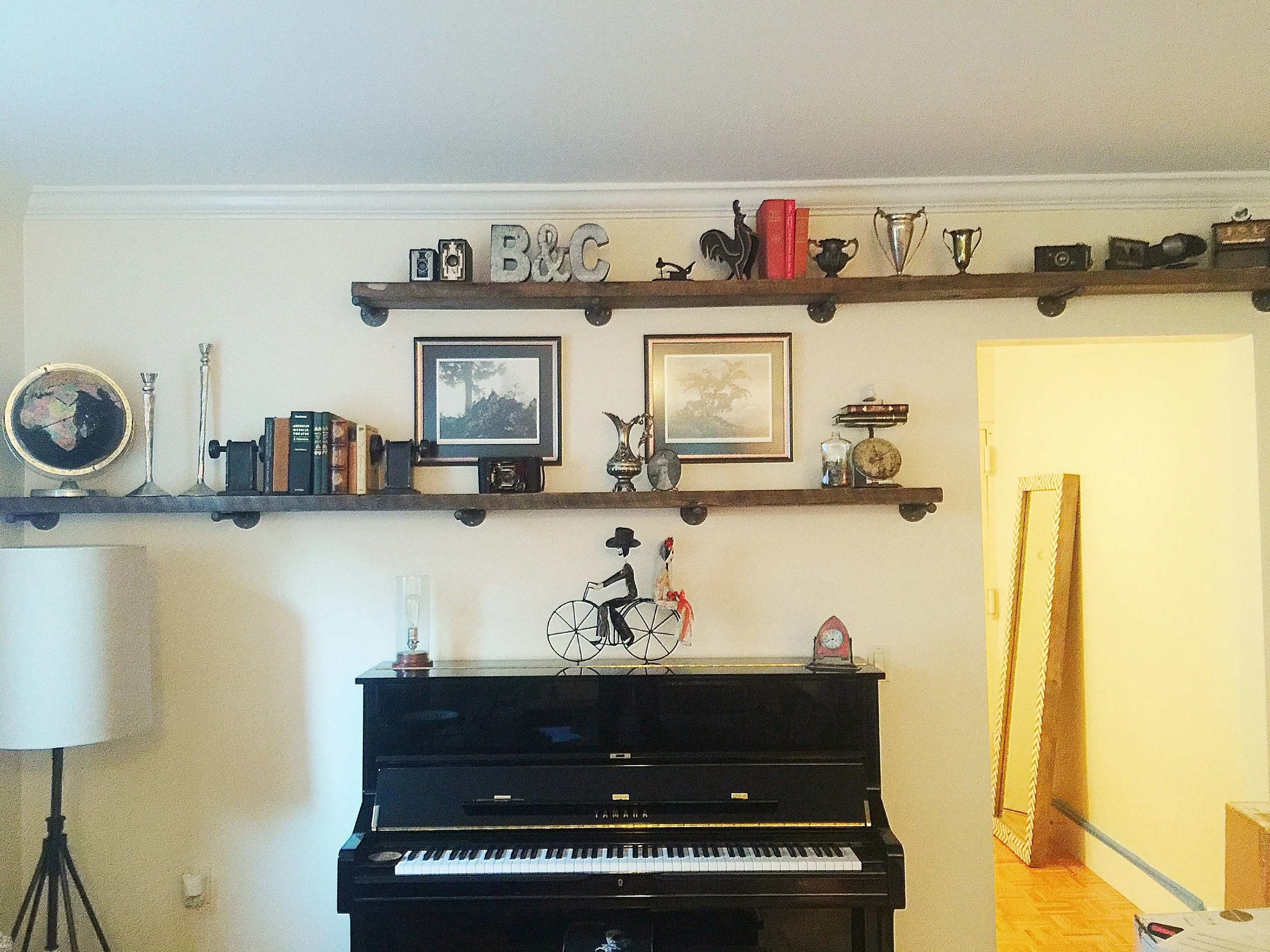 Space above the floor lamp and doorway was used to bring the focus in this area up above the piano for a cool eclectic look.