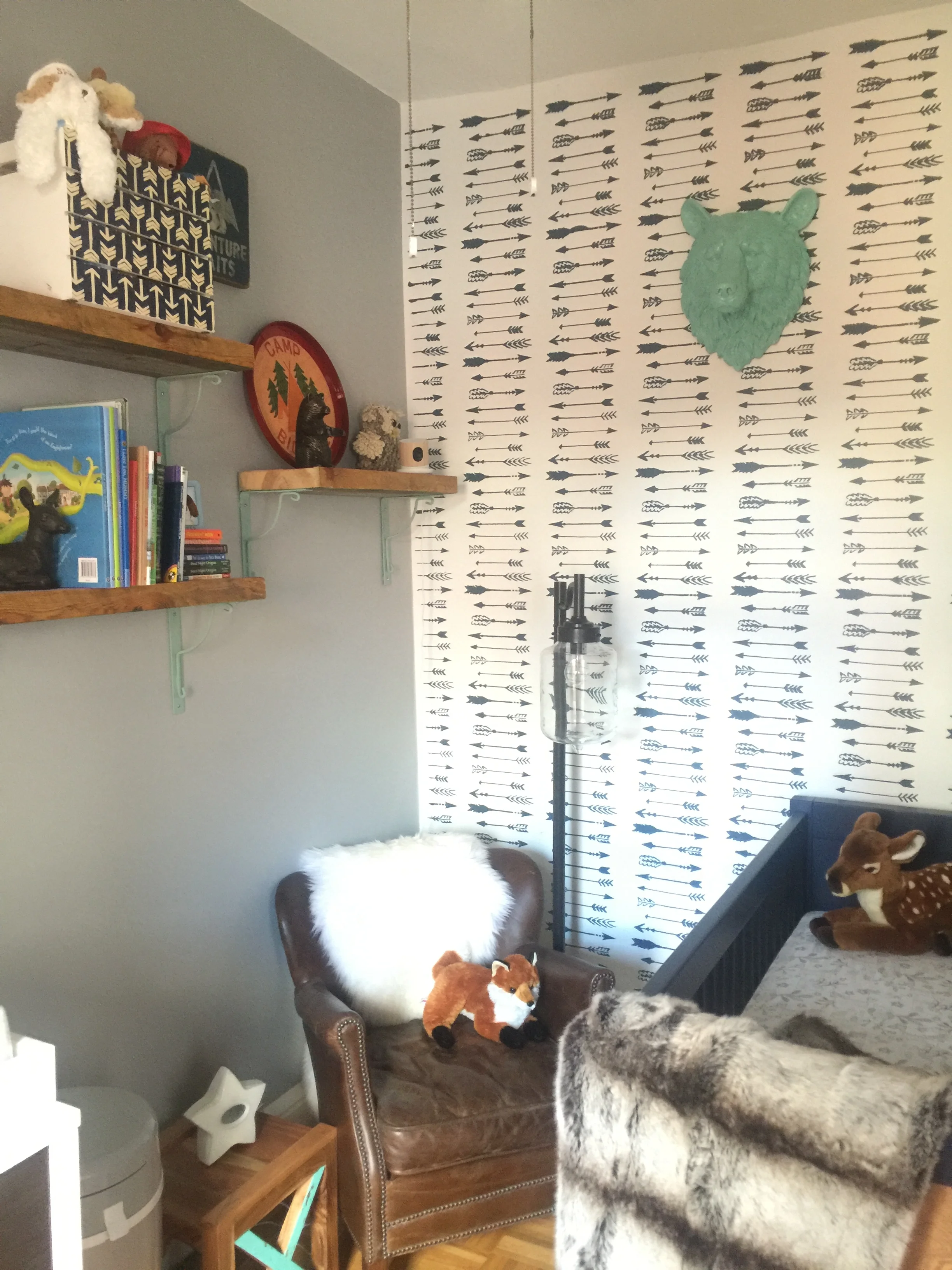 Mint metal brackets tie the wooden shelves in with the rest of the space and decor,while adding a small pop of color against the gray wall.