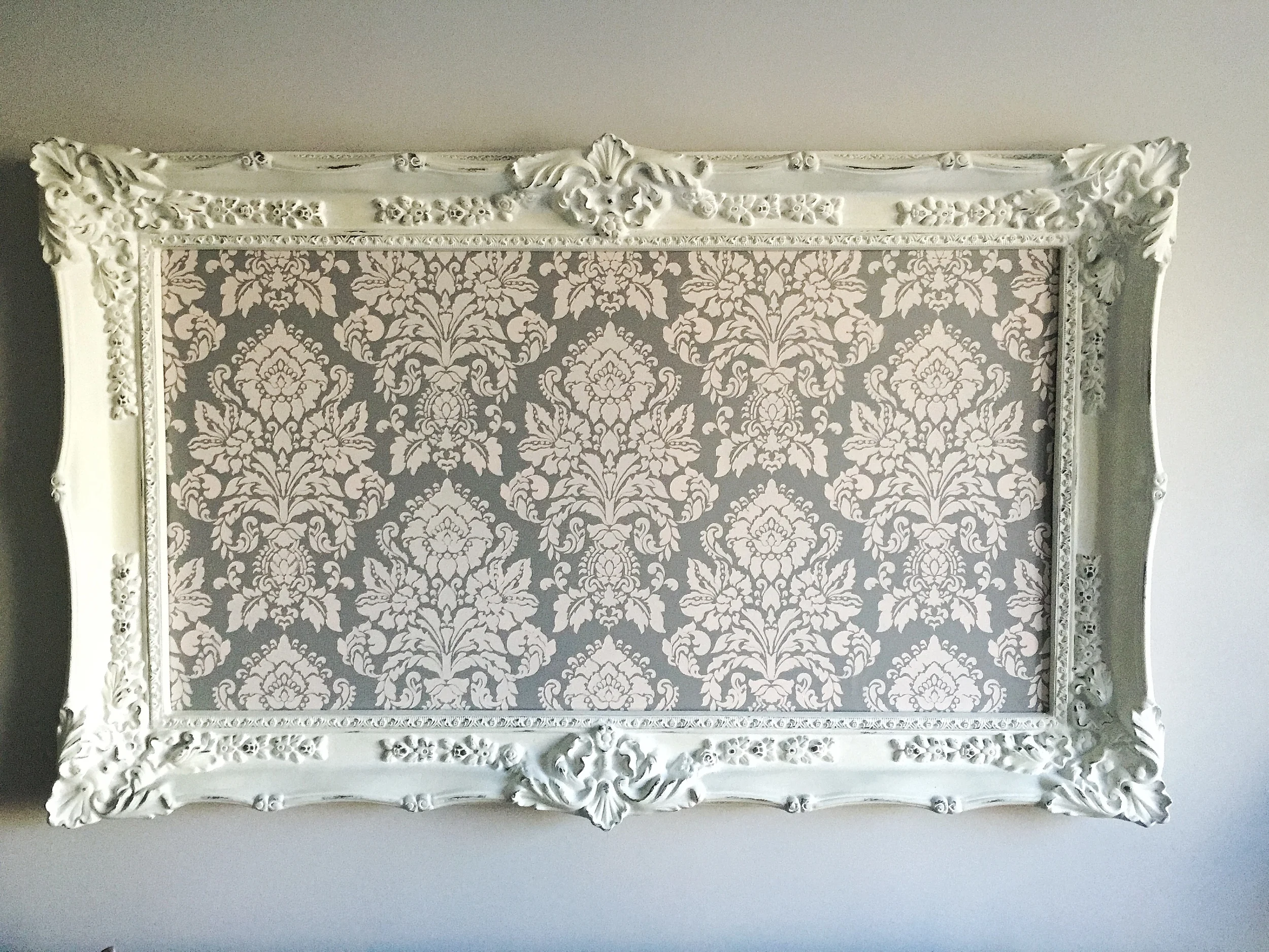  Our client fell in love with a damask stencil that we painted in custom colors and framed as a one of a kind statement over the sofa.