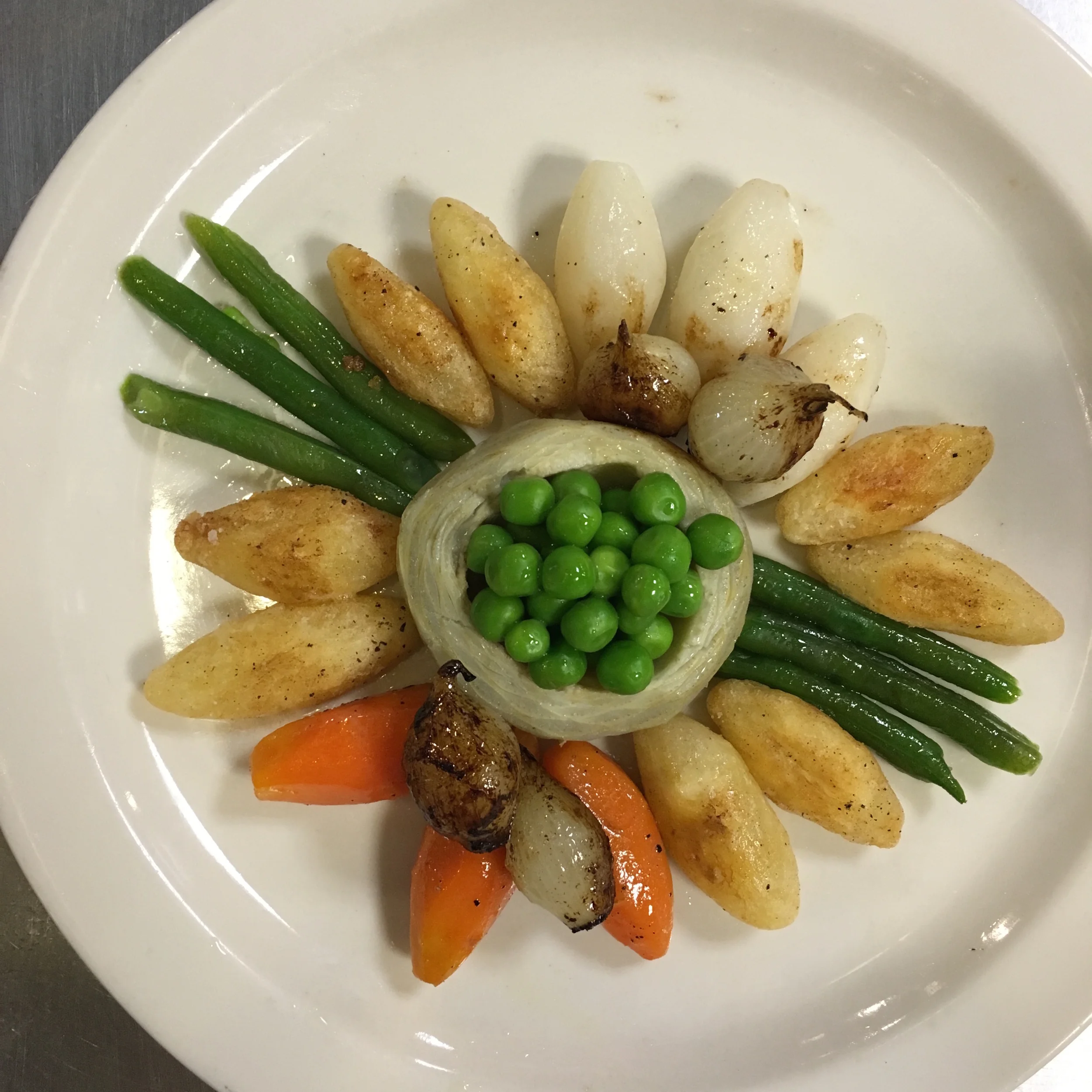 The artichoke heart in the center serves as the "bowl" for the peas 