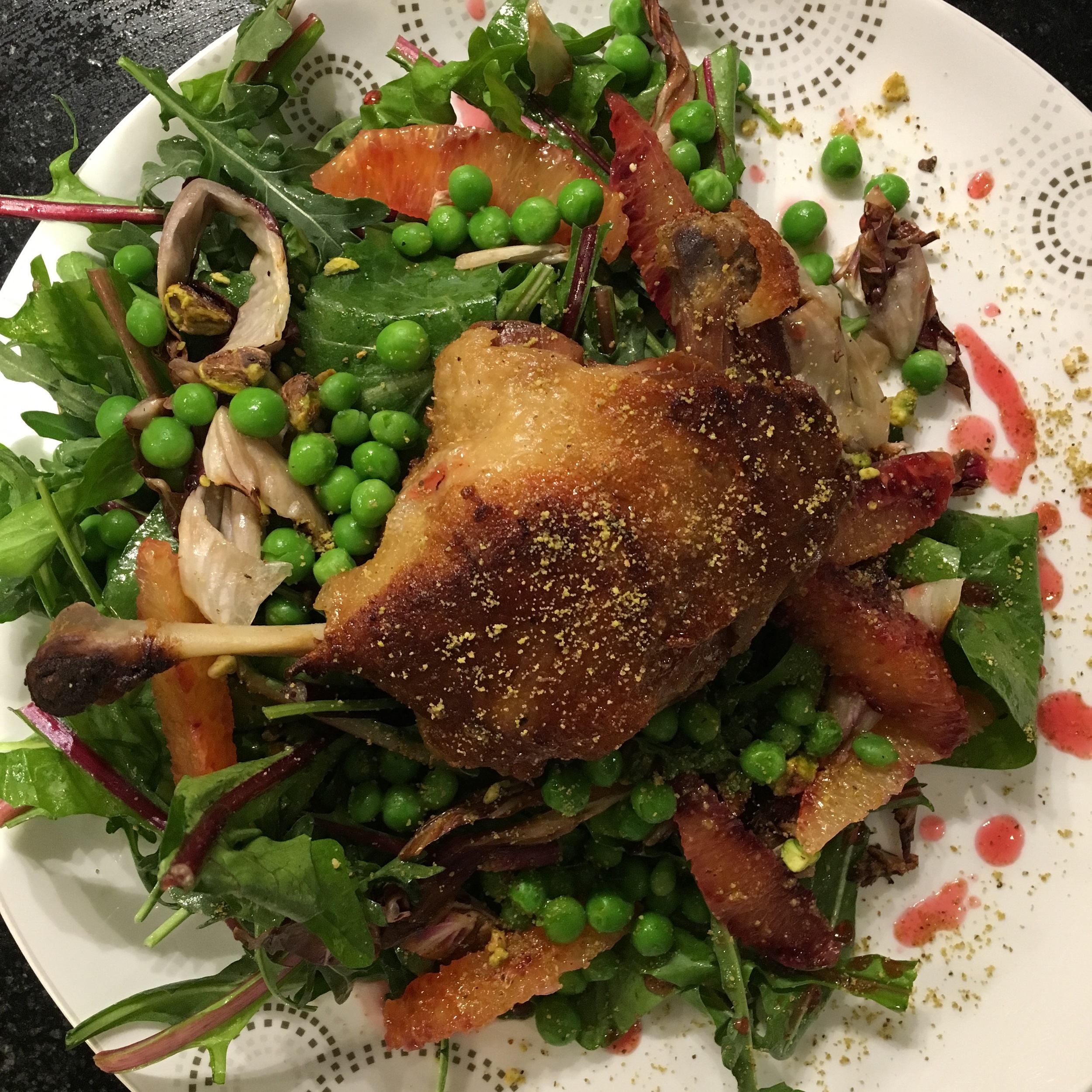 THE CRISPY LEG WAS PLACED ON TOP OF SIMPLY DRESSED DANDELION GREENS AND ARUGULA, BLOOD ORANGE SUPREMES, BUTTER PEAS, CHARRED RADICCHIO, PISTACHIO AND FINISHED WITH A BLOOD ORANGE GASTRIQUE AND PISTACHIO DUST.