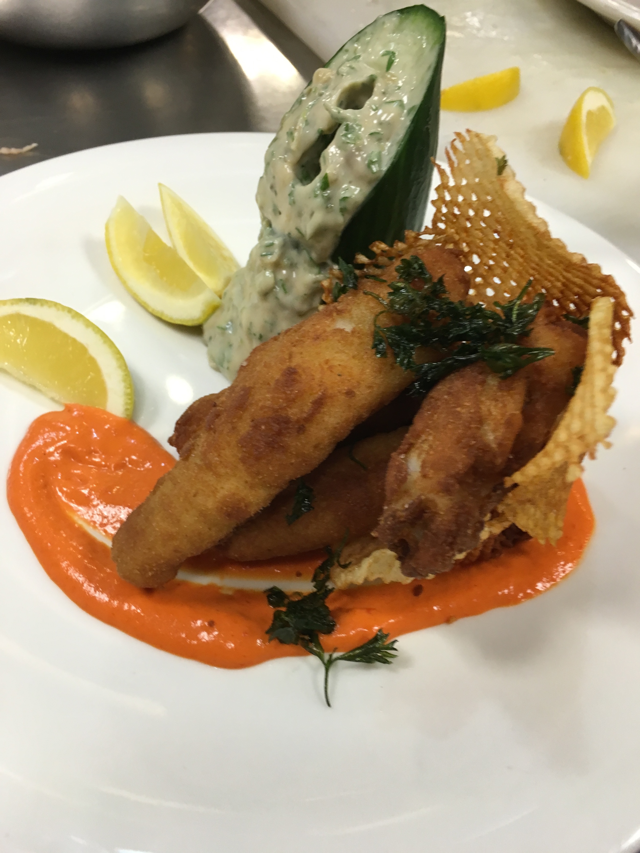 It was served in a waffle potato basket over Sauce aux Poivrons Rouges (red bell pepper) and Sauce Remoulade and fried parsley.