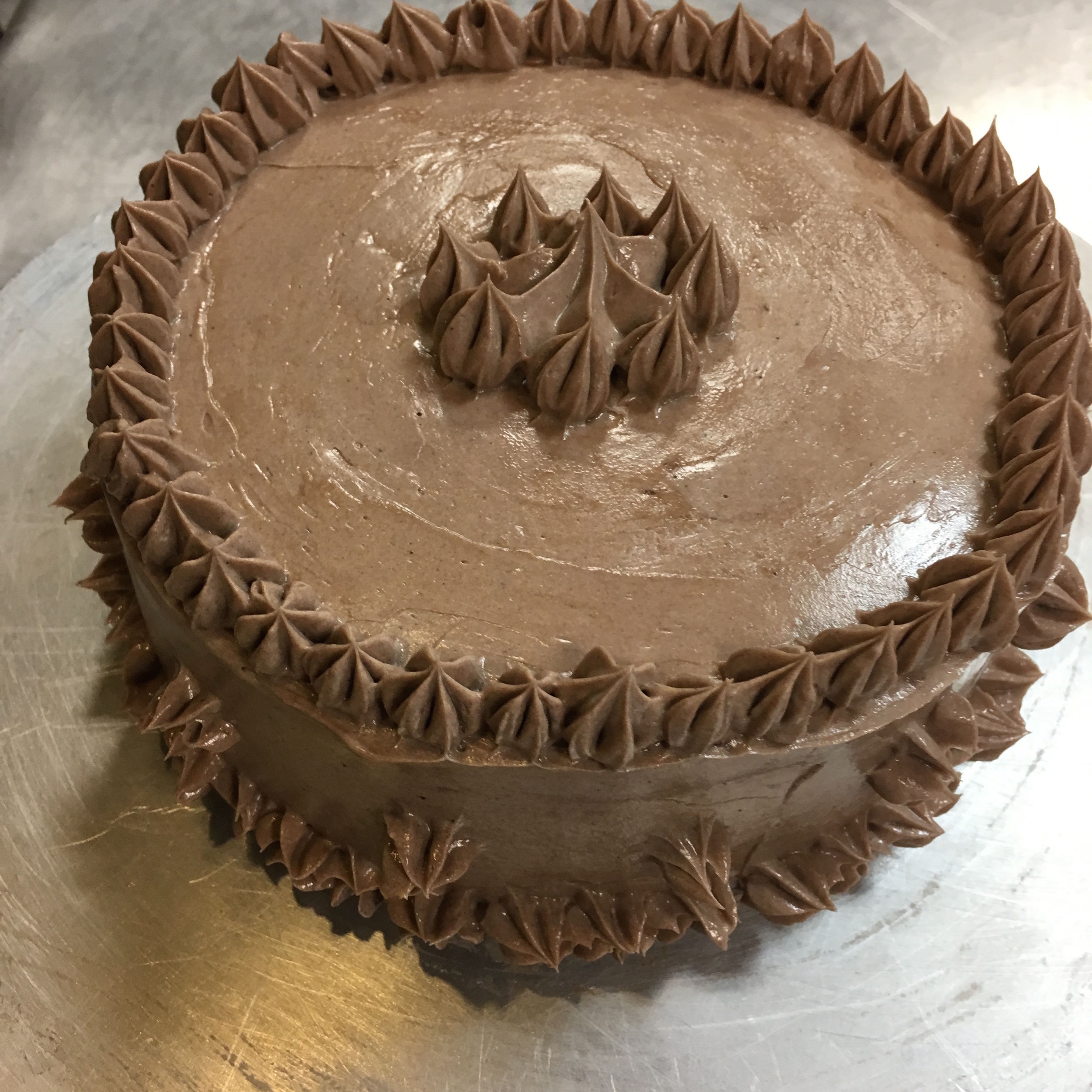 THE CAKE WAS OK. MY FIRST GO ROUND WITH THE GENOISE BATTER WAS A FLOP. I OVER-BEAT IT WHICH LED TO IT BEING EXTREMELY DENSE. THE SECOND ATTEMPT WAS MUCH BETTER BUT EVEN STILL NOT A+ MATERIAL. WE SOAKED THE LAYERS WITH A SIMPLE SYRUP TO PROVIDE SWEETNESS AND MOISTURE, WHICH HELPED COUNTERACT IT'S DENSENESS. THE BUTTERCREAM FROSTING CAME OUT AS PLANNED, HOWEVER, IT IS VERY RICH. NOT MY CUP OF TEA...