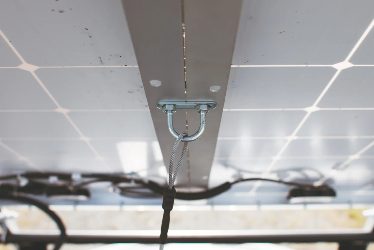 The U bracket in the middle has a vinyl-coated wire attached. This prevents the solar panels from moving past a 90-degree angle.