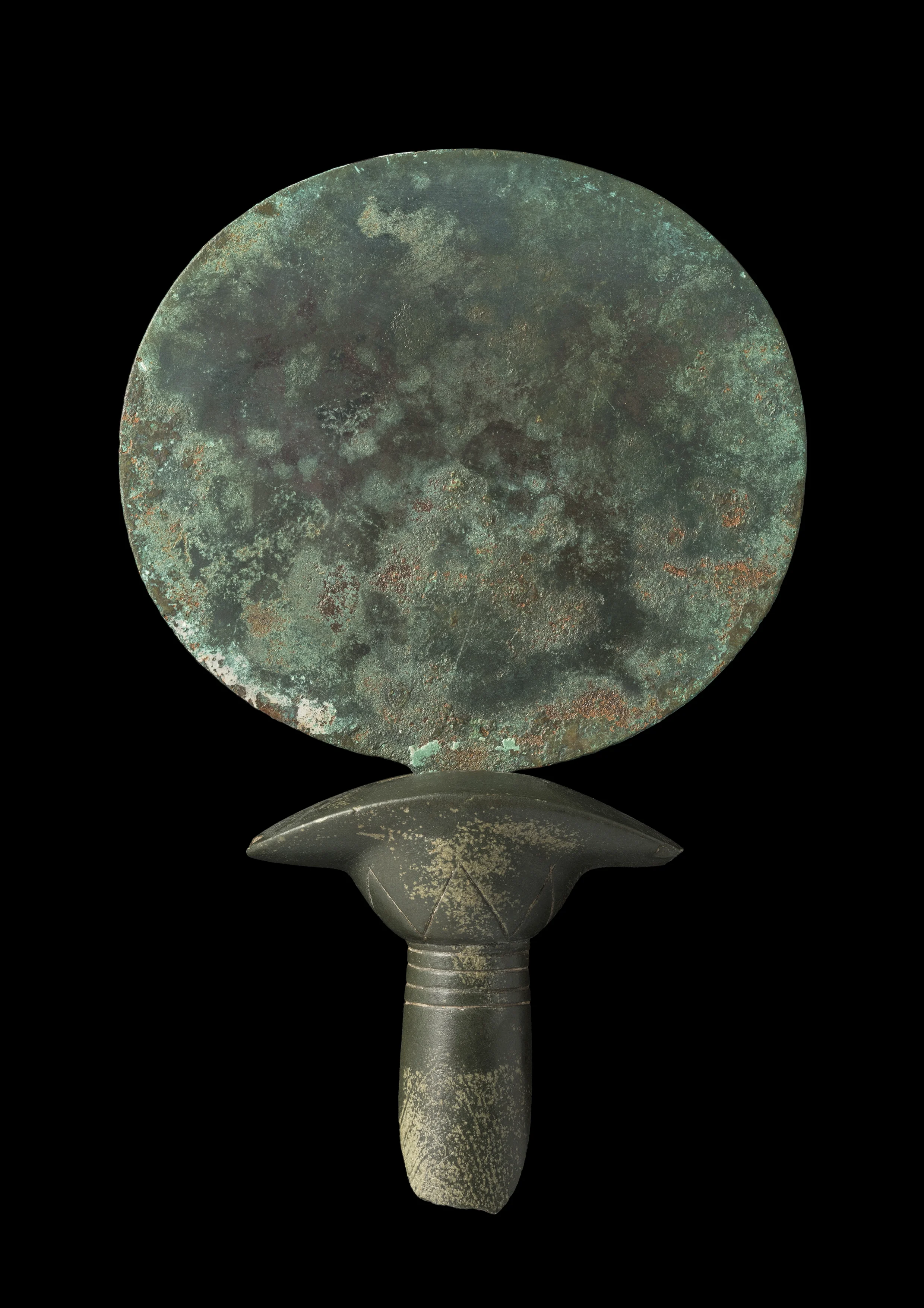 A copper alloy mirror with the upper part of a stone handle preserved in the shape of a papyrus column; Late Middle Kingdom (2055-1650 BC). Courtesy Two Temple Place and Macclesfield Museum
