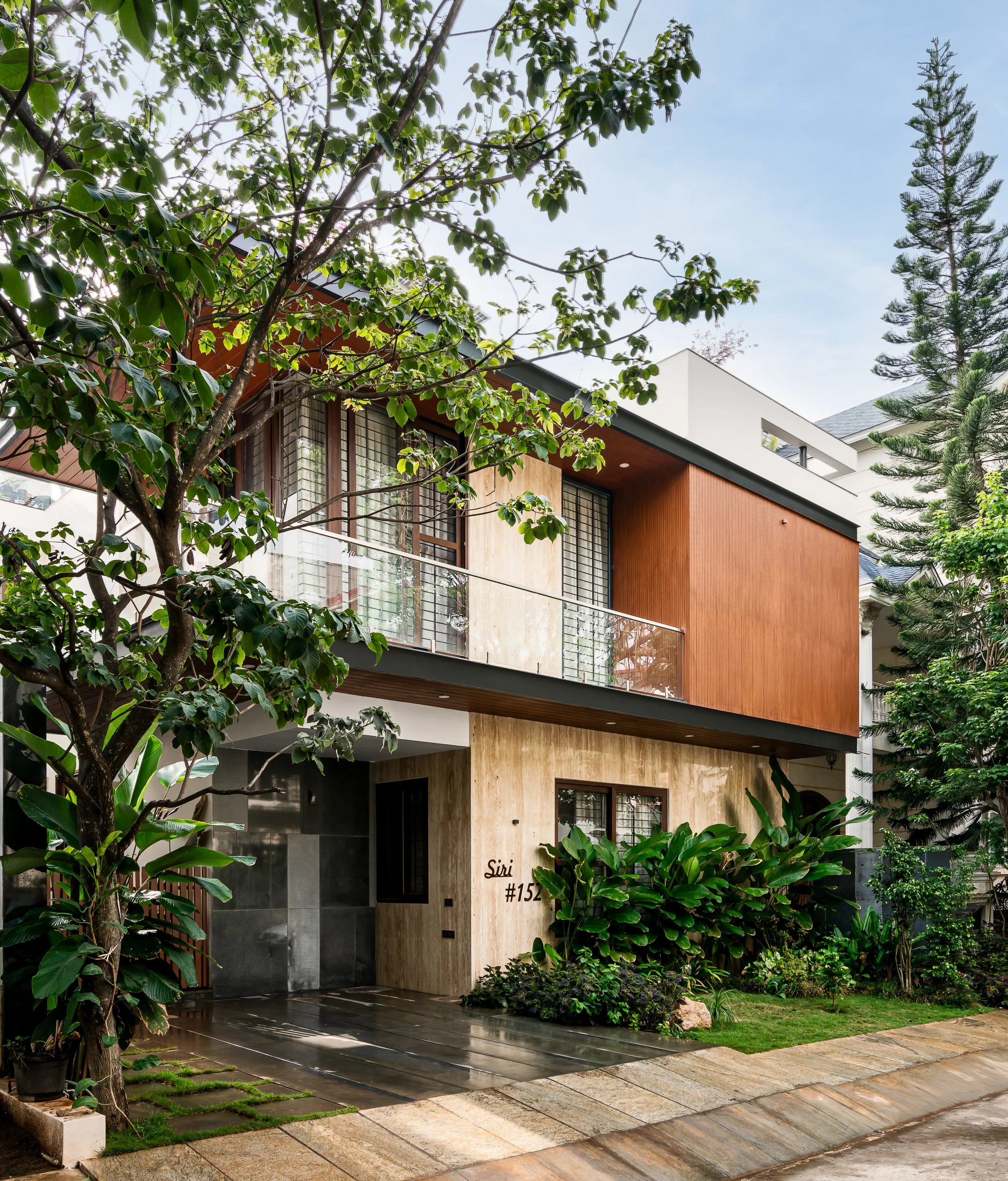 The house from the street, under the trees