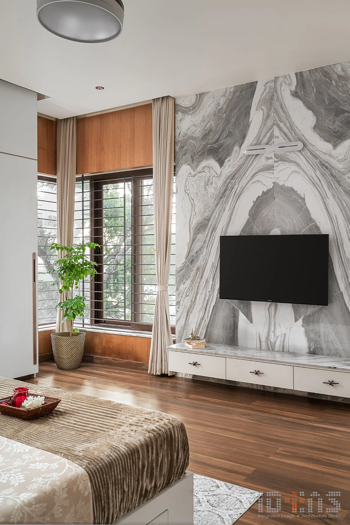 Bedroom with a television and marble wall