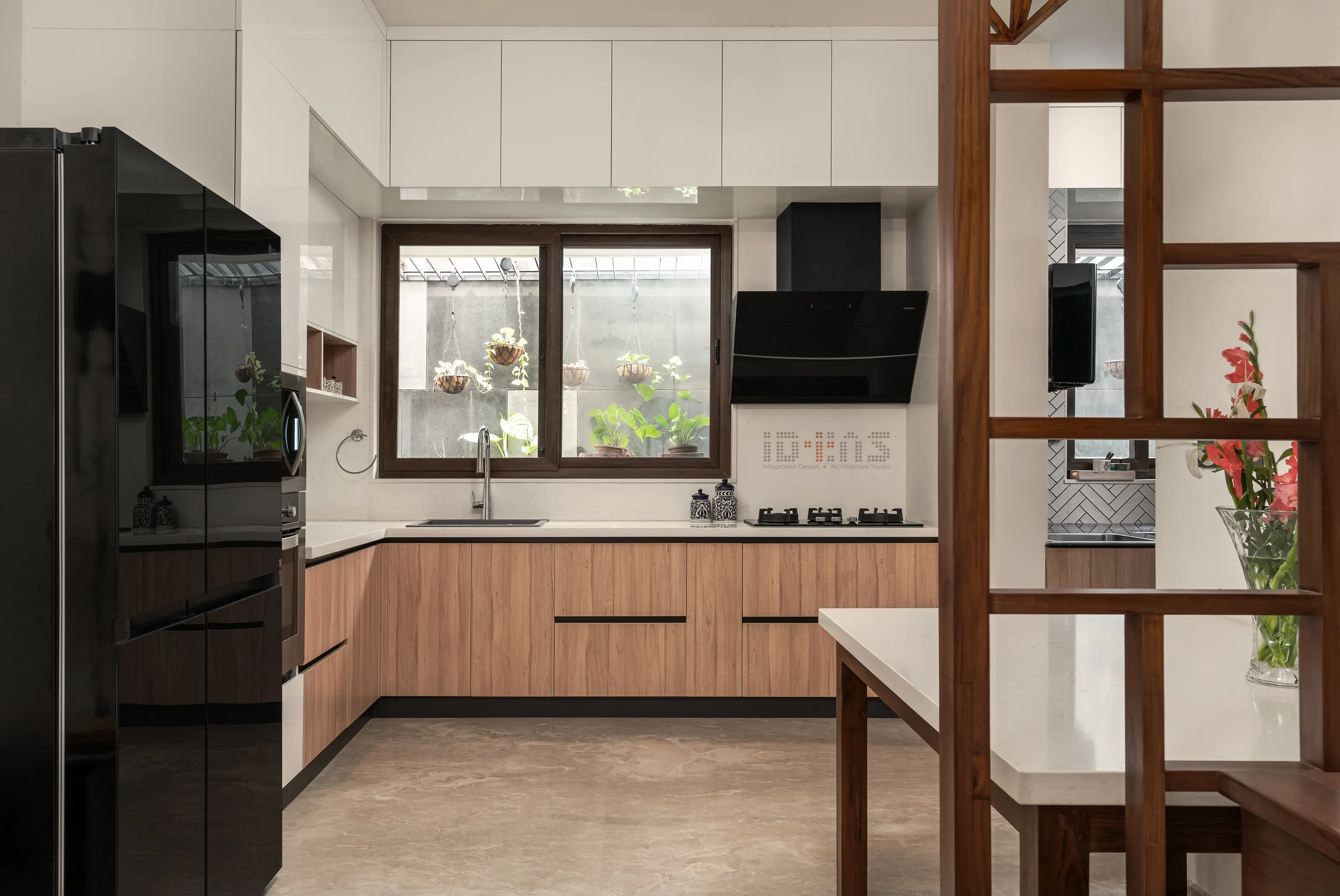 Kitchen with pale joinery and a black fridge
