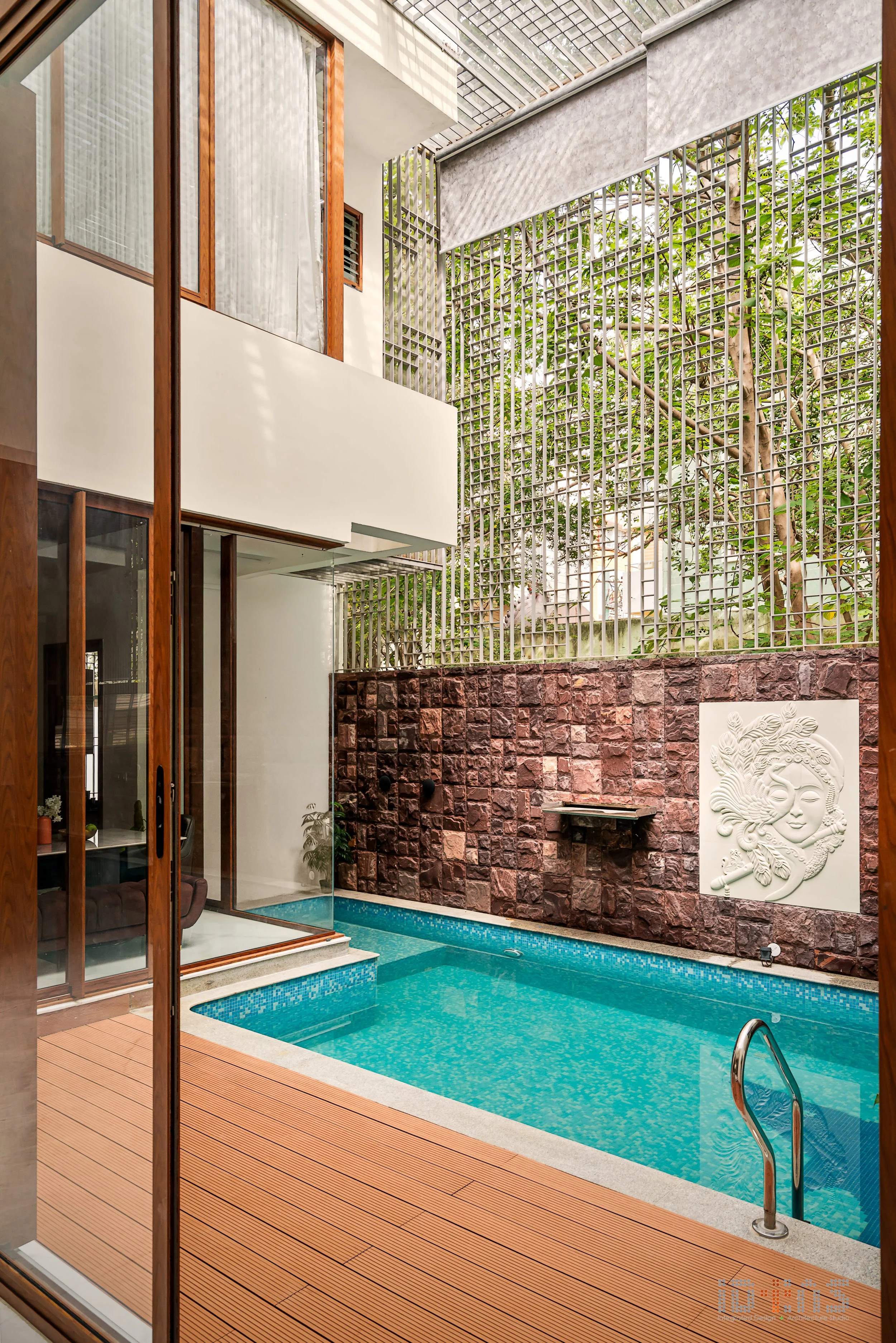 The pool seen from the passage, through planting