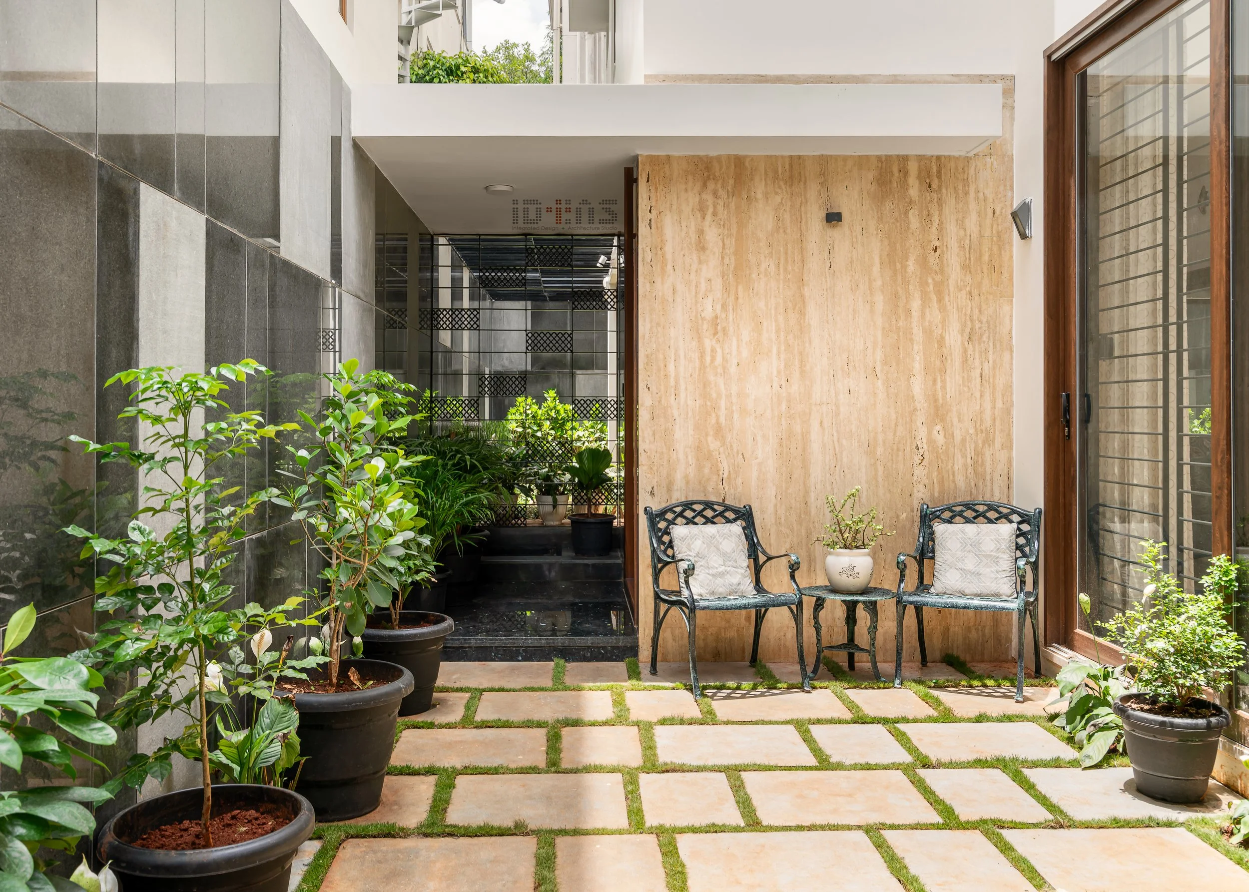 Courtyard at the door: planting, chairs and patterned paving