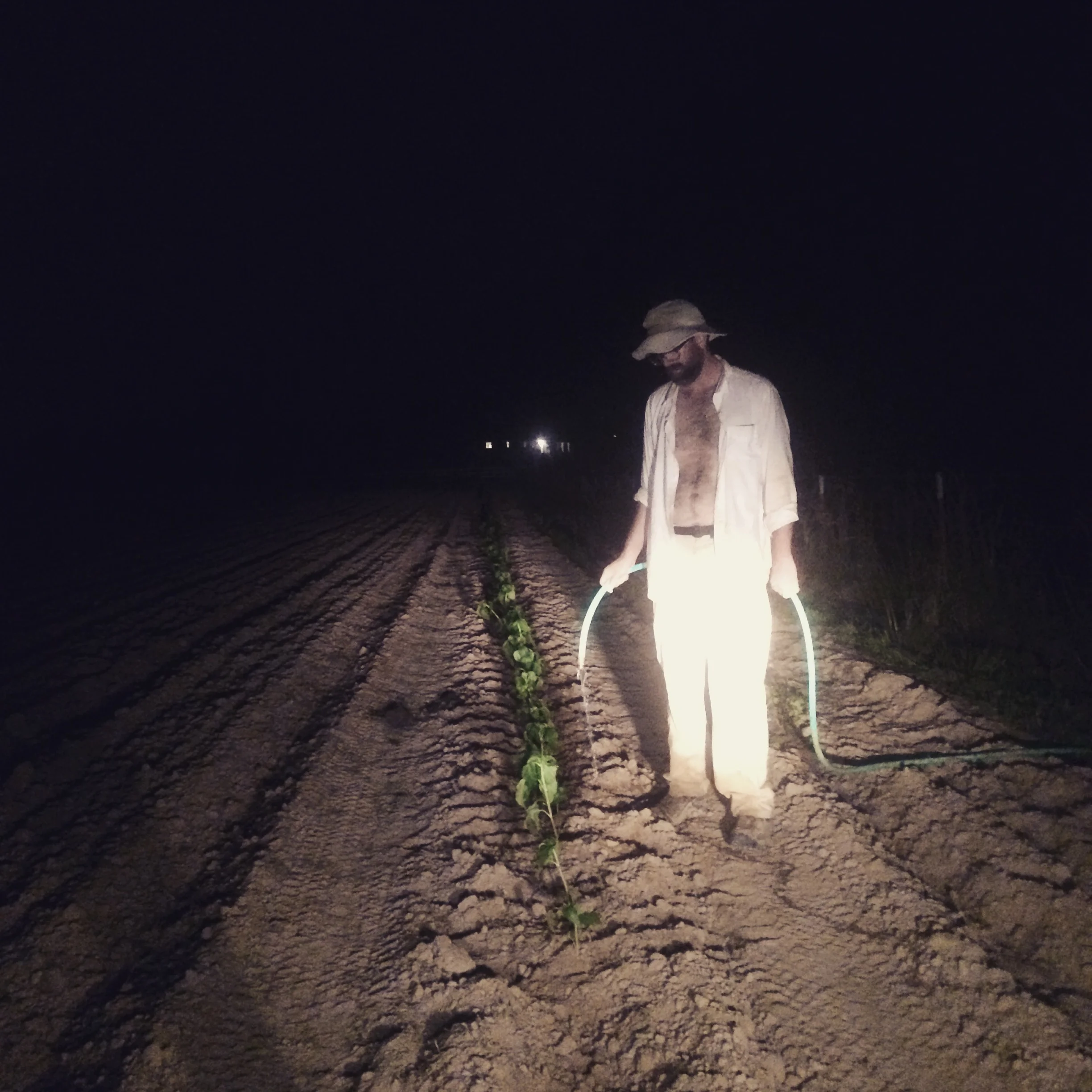 Jesse watering in plants after a long day of transplanting