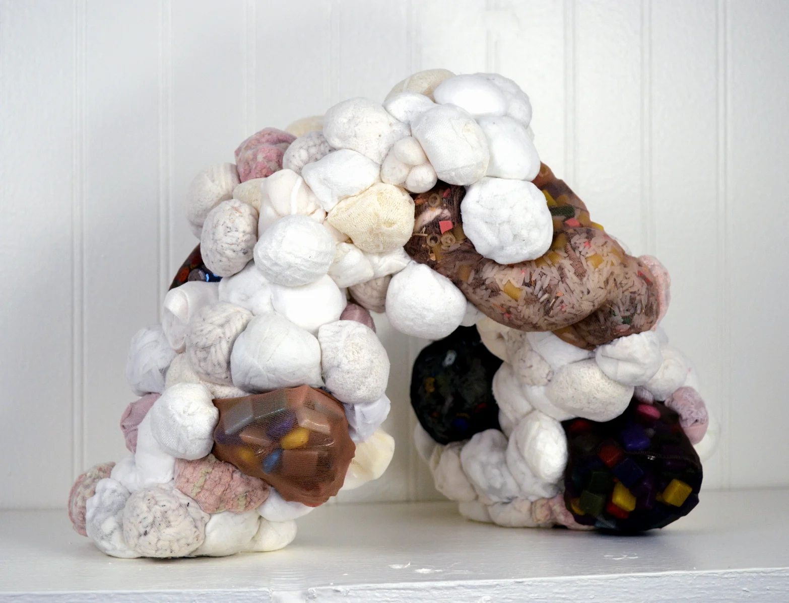 Color Conferred (2017) rice, glitter, sequins, rhinestones, nylon stockings, towels, q-tips, rug mats, mop, sponges, silk slips, bath loofahs, napkins, bath mats, balloons, packing peanuts, cotton balls, face pads, underwear, diaper pins, pasta, mosaic tiles, waxed linen thread 14” x 18” x 12” * Title inspired by the poem “C-Section” by Alexis Pauline Gumbs