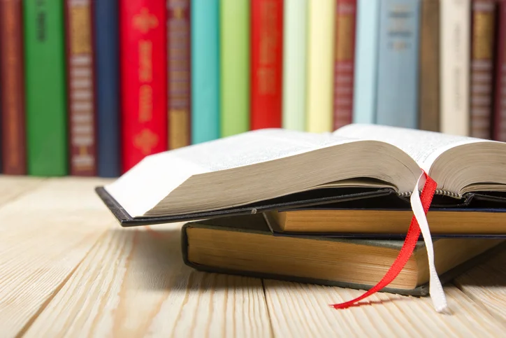 Open-book,-hardback-books-on--wooden-table-485727930_727x484.jpeg