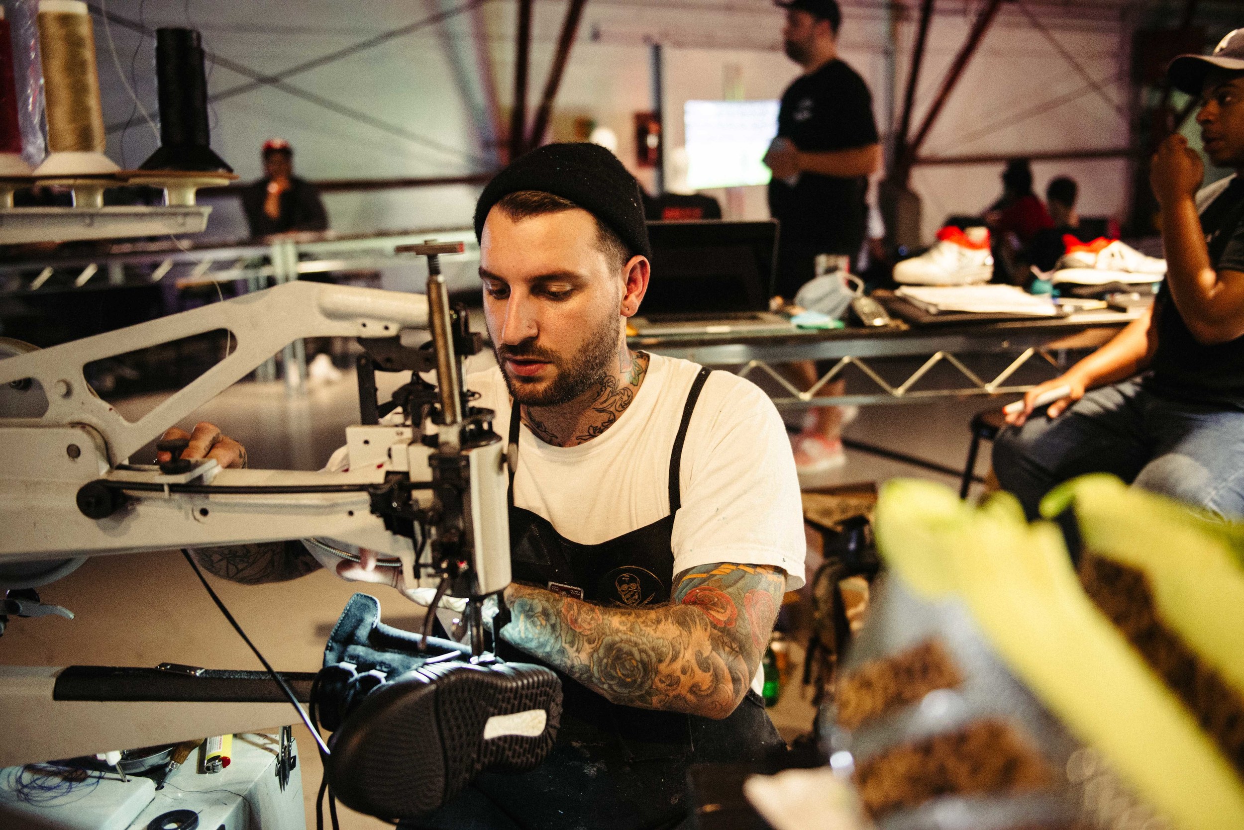  The Shoe Surgeon (Dominic Chambrone) customizing soccer cleats – and &nbsp;black Yeezy 750's –&nbsp;at Adidas' Mercury Center. / Photo: © Diane Abapo for SUSPEND Magazine. 