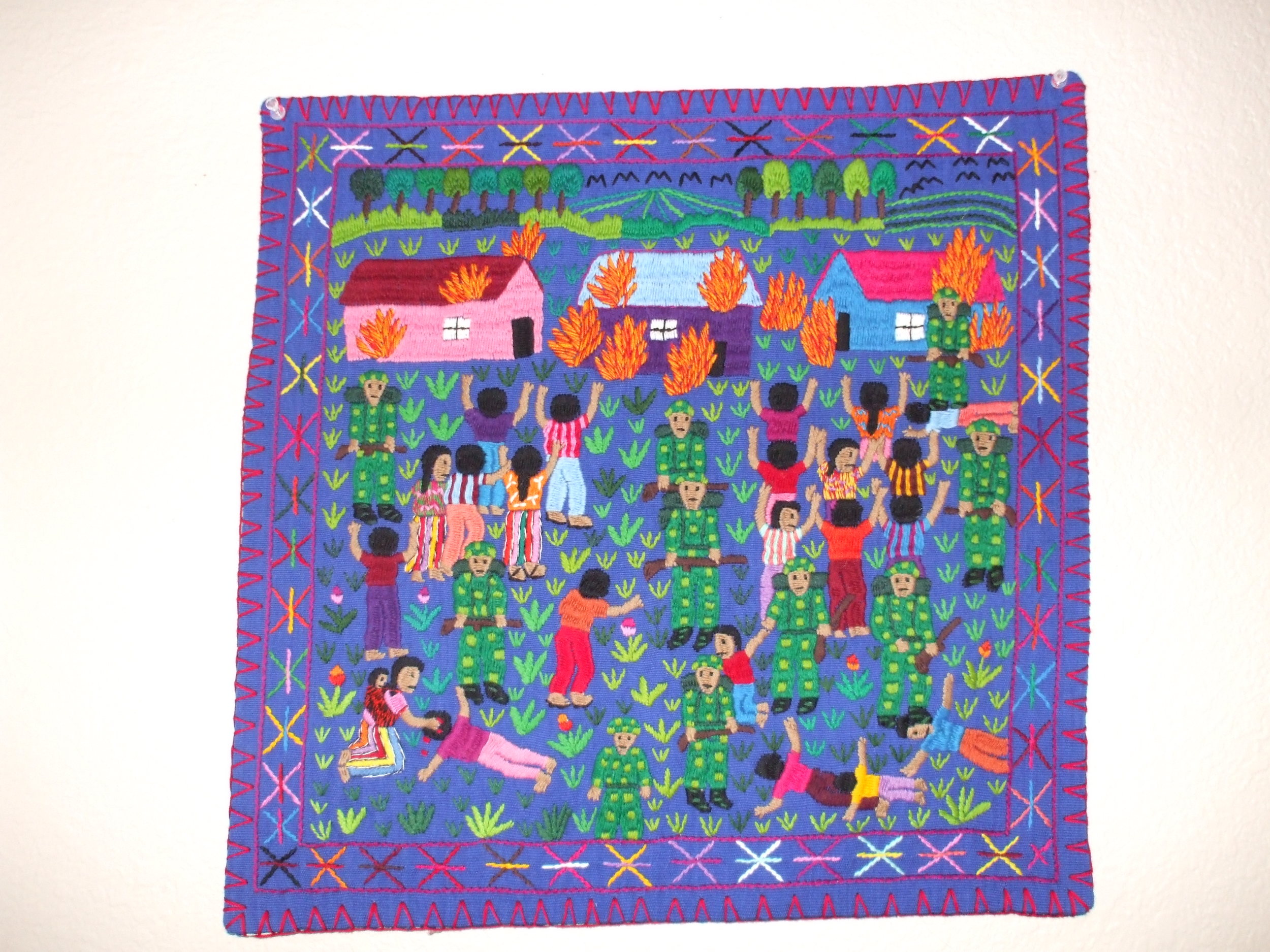This arpillera is from a workshop in Guatemala started by Ramelle Gonzalez. She had to teach the Mayan women to embroider since they previously used weaving. Polyester yarn on cotton background. Photo courtesy of Dr. Deborah Deacon.