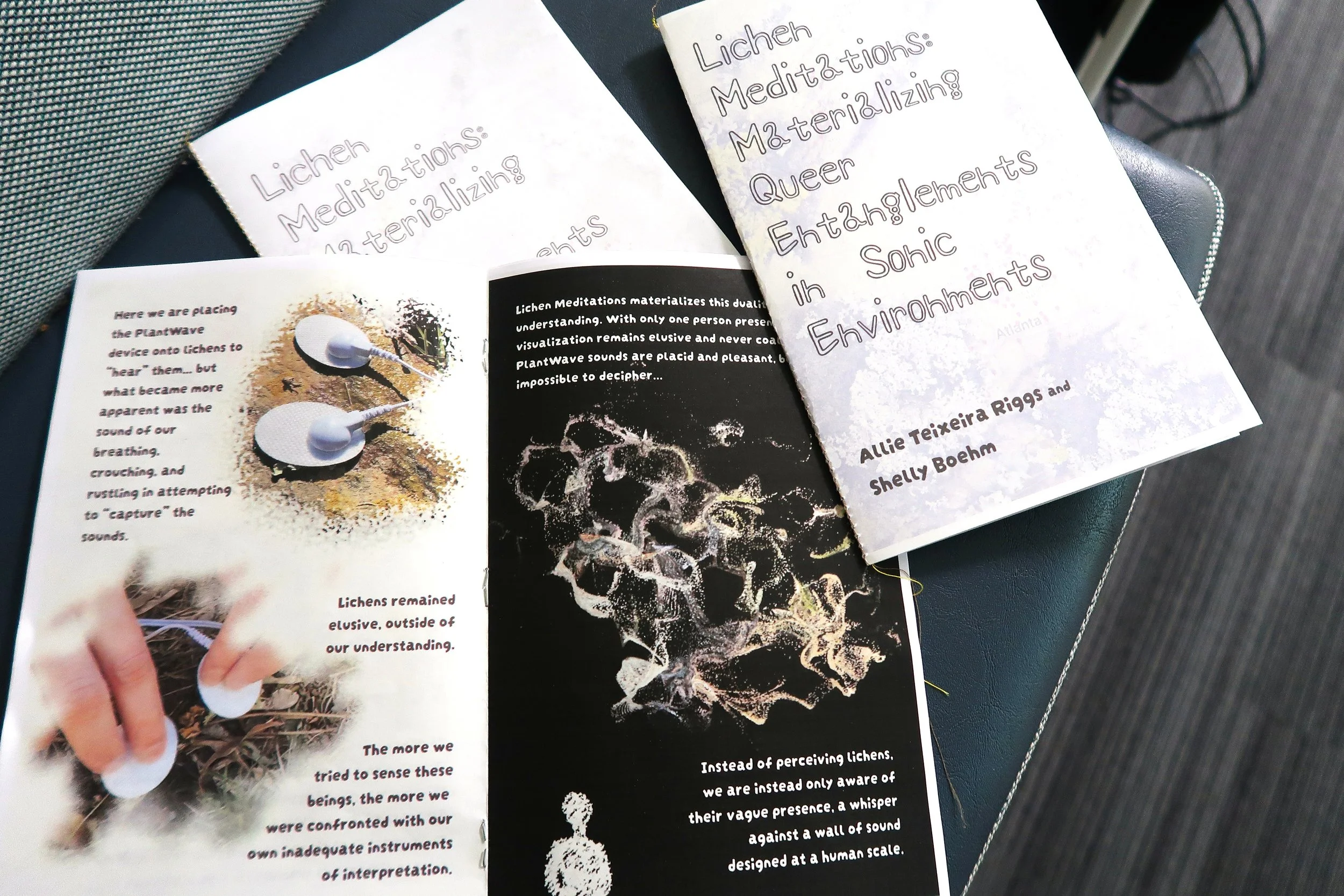 Photo of several copies of the zine, Lichen Meditations, by Allie Teixeira Riggs and Shelly Boehm. The zine has a white cover and black and white internal pages with photos and graphics. Photo:  Pearl Kaplan/Tech Square ATL.