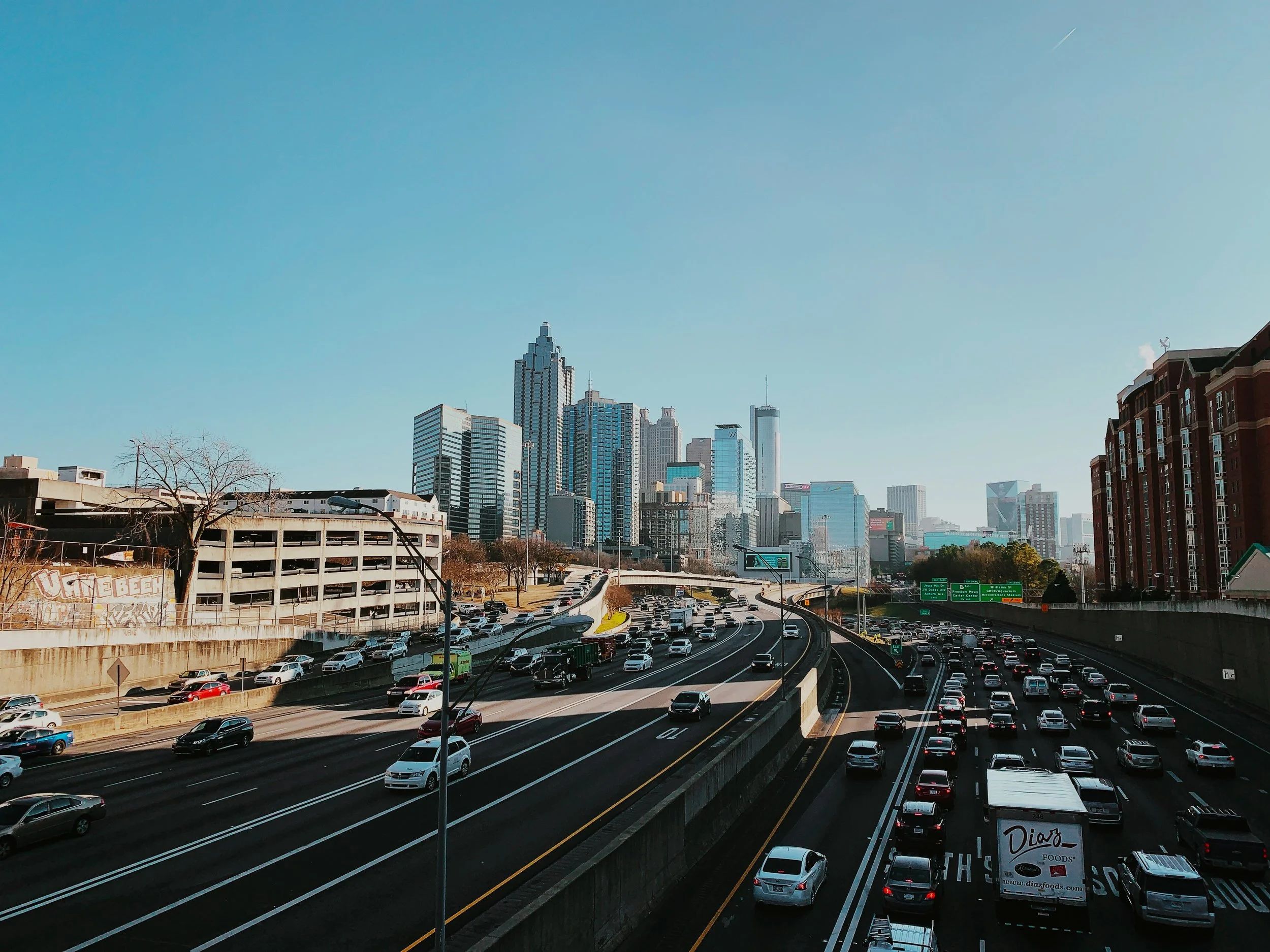Photo of the City of Atlanta skyline and multi-lane highways in the foreground. Source: Jason Weingardt, Unsplash.
