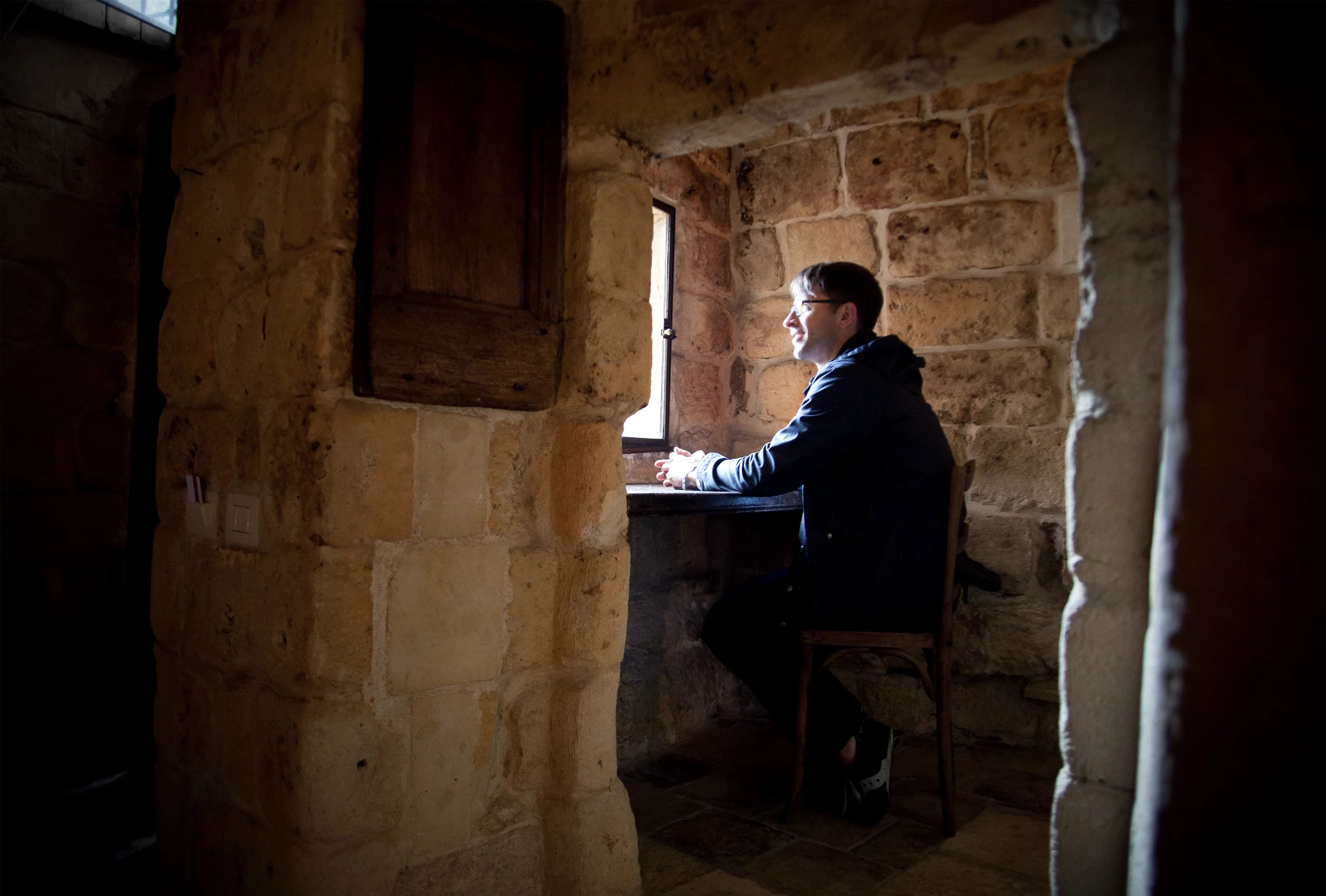 My husband David sitting at the little letter writing desk in our room at the Sextantio Le Grotte della Civita in Matera, Italy, 2013.