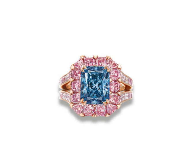  An exceptional colored diamond ring by Moussaiff. The rectangular-cut fancy vivid blue diamond, weighing approximately 3.98 carats, within a cushion and triangular-shaped pink diamond surround.&nbsp; 