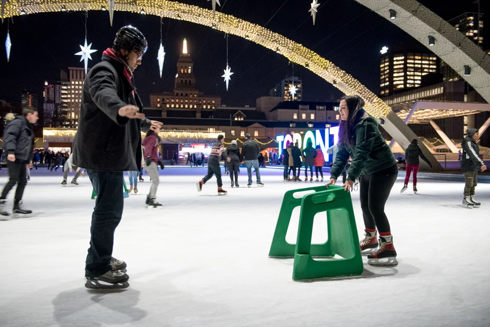 Balance is a key, his friend close at hand with the skating aid.