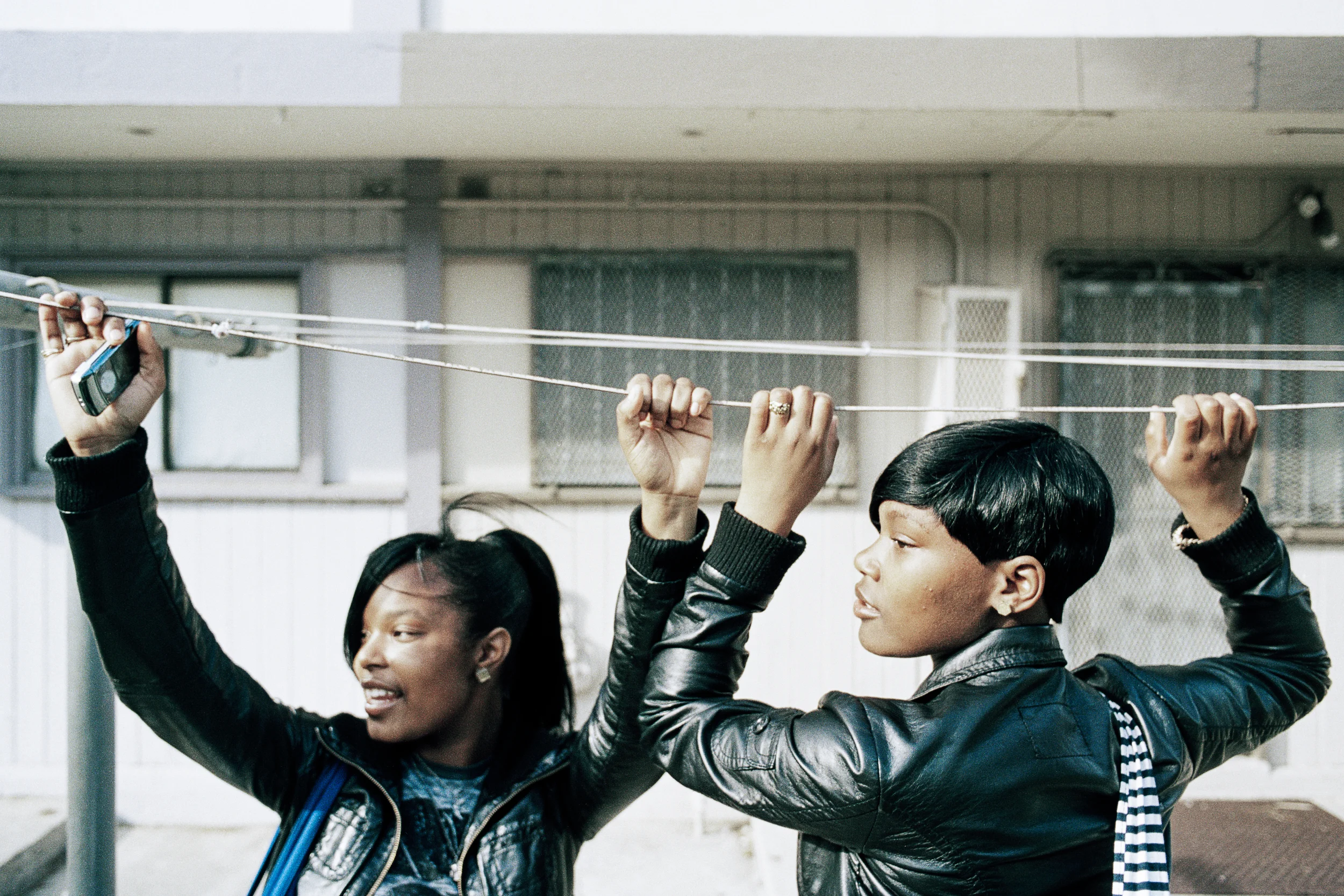 Girls hang from a laundry wire in Hunters View, 2009.
