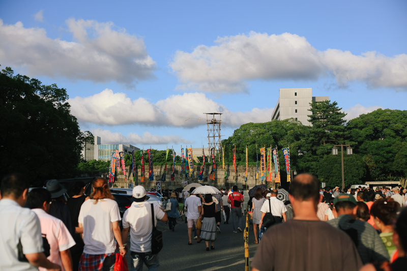Making our way out of the stadium. Nagoya castle is right next to the stadium and a watch tower over looks over a moat, containing two men playing the drums as everyone exited the premises. 