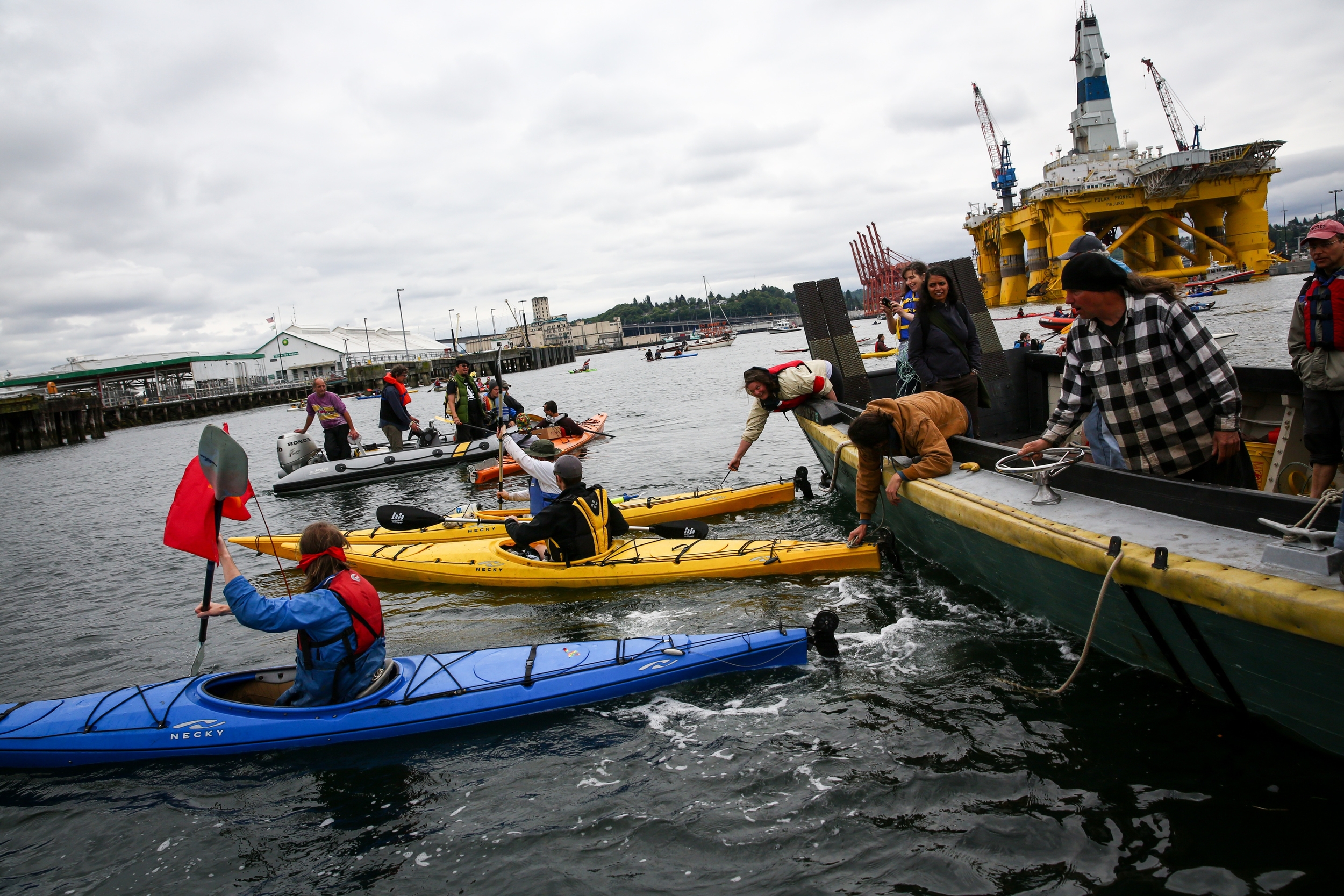   People use kayaks to position a protest boat as hundreds of kayaktivists take to the water during protest against drilling in the Arctic and the Port of Seattle being used as a port for the Shell Oil drilling rig Polar Pioneer. The protest flotilla