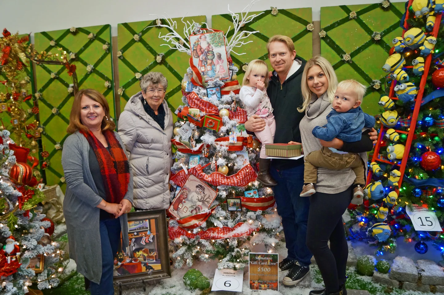 HFHIV Executive Director Tammy Marine and CTL Chairperson Vicki Puterbaugh stand with the winning family of the Gift Card Tree. 