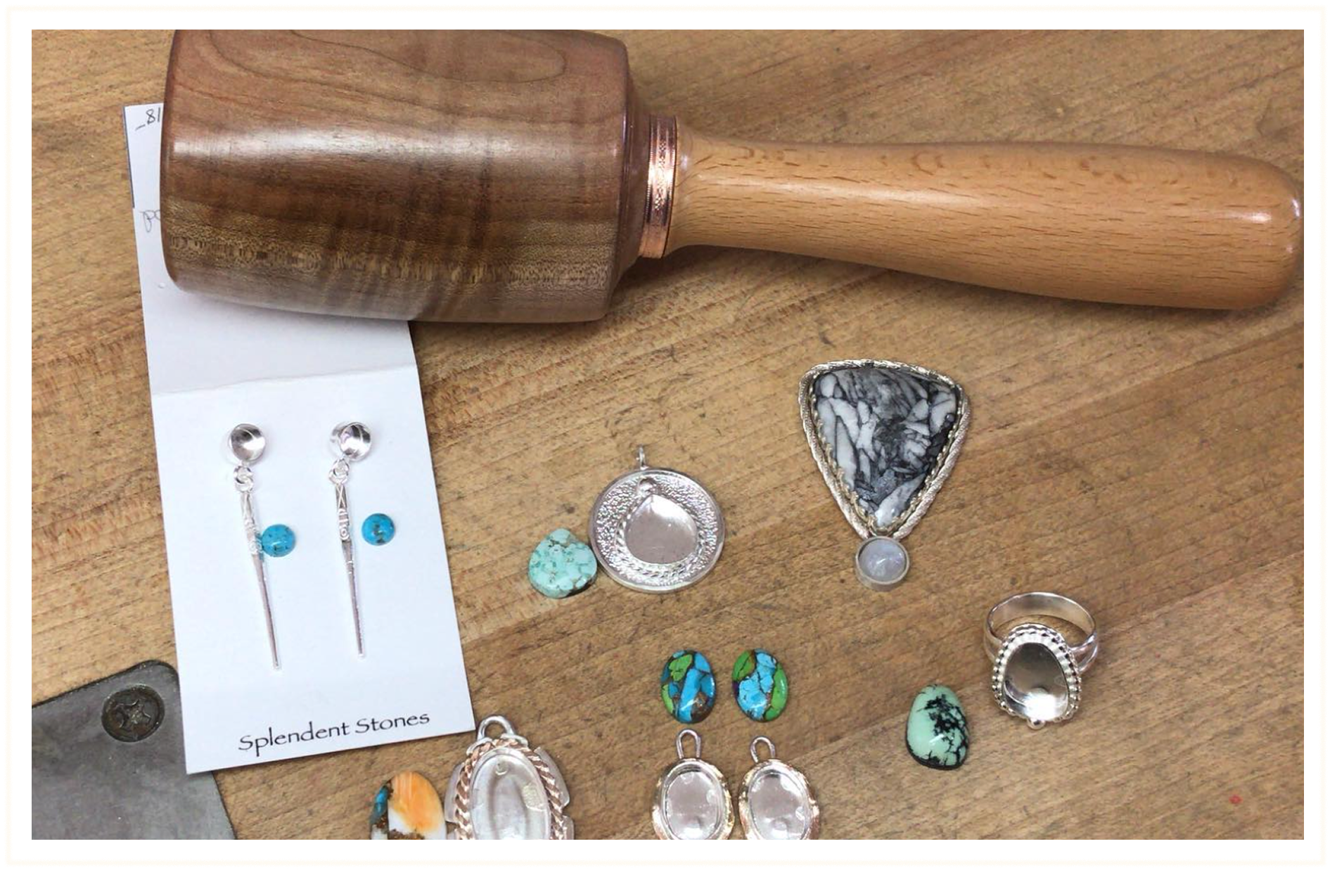 Various jewelry pieces, including turquoise and silver earrings, a turquoise stone, a large marble-style pendant, a ring, and rings, spread out on a wooden surface. A wooden mallet is positioned at the top of the image.