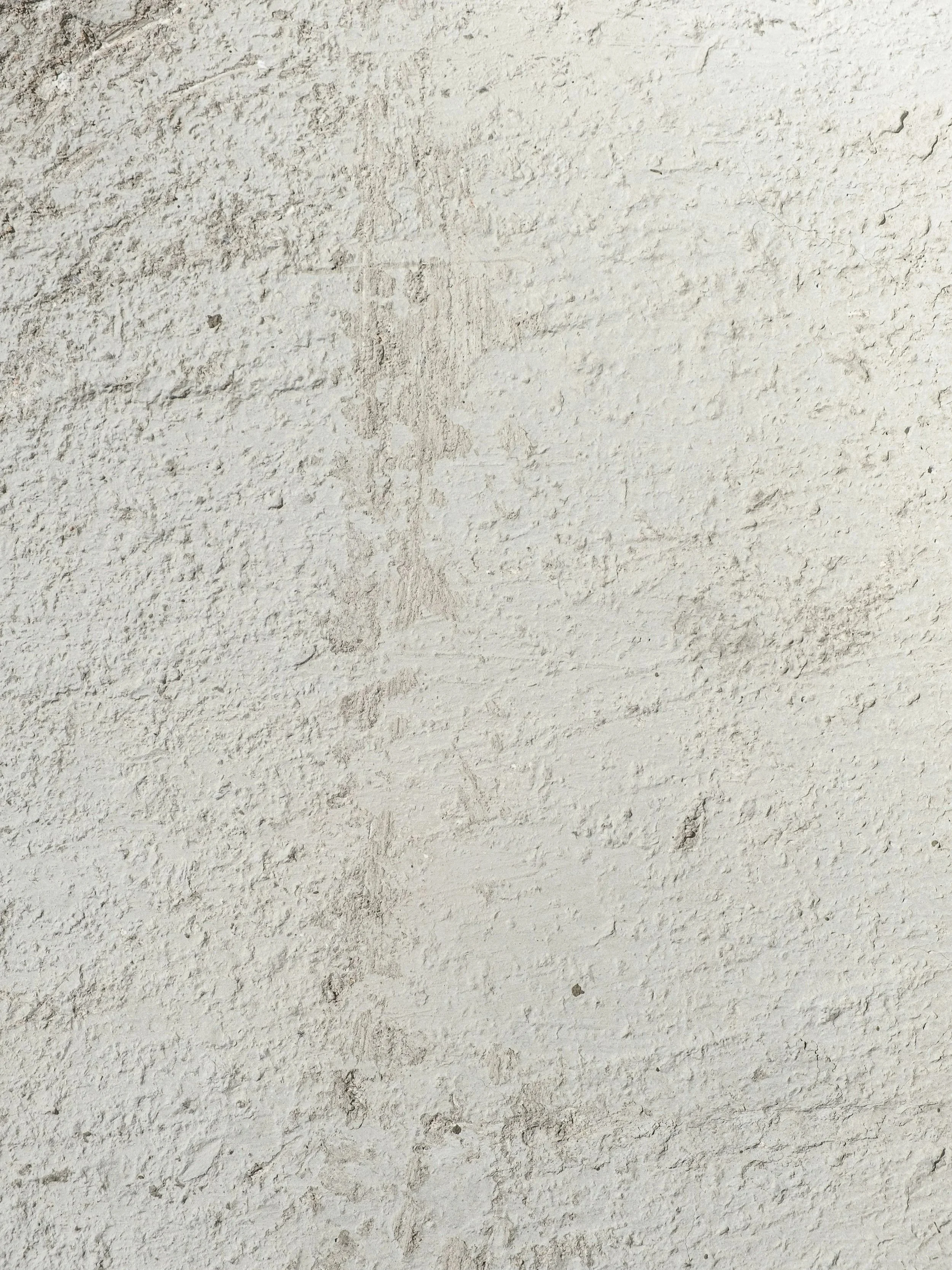 Close-up of a white textured wall with some visible imperfections.
