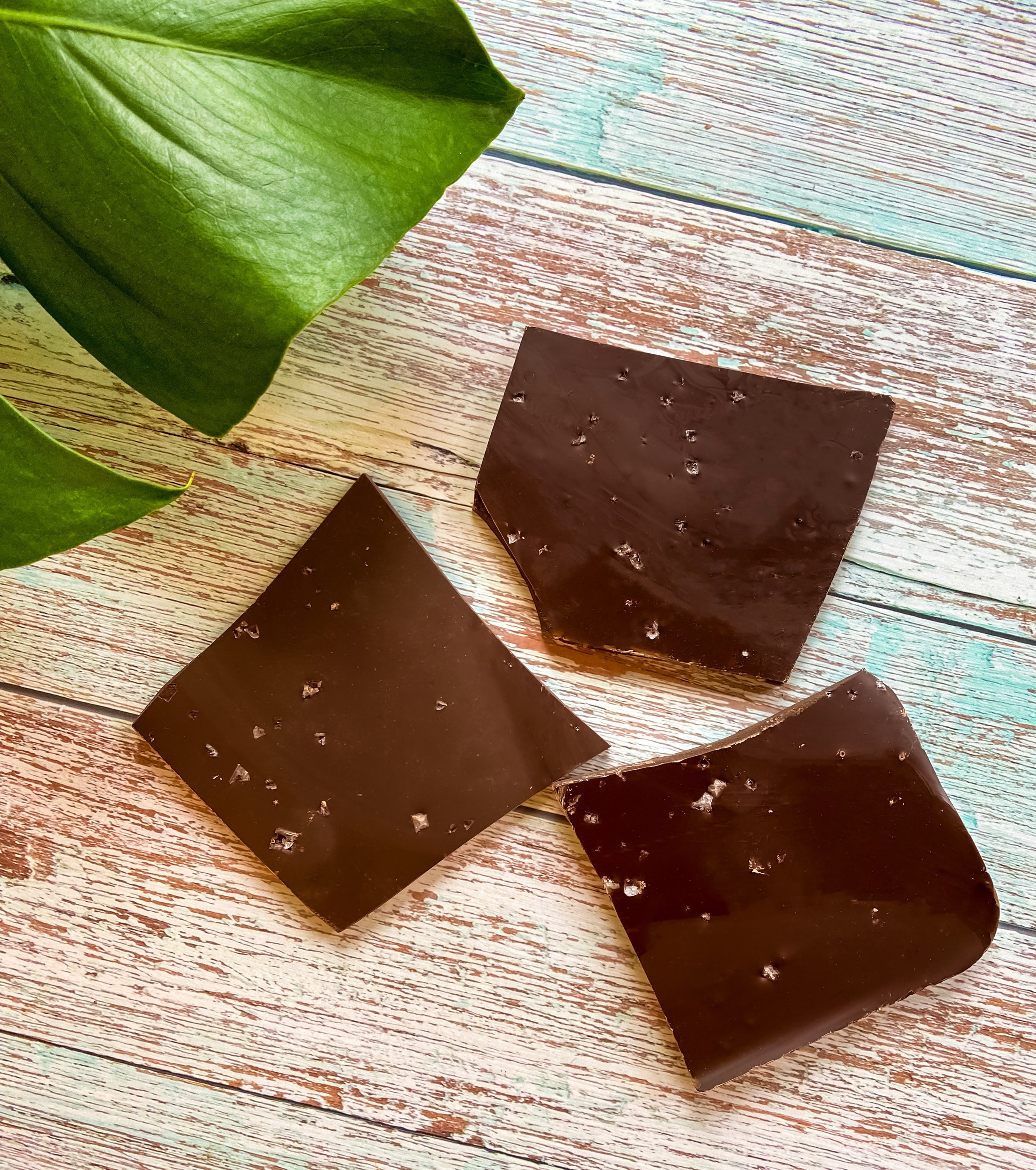 Close-up of sea salt flakes on dark chocolate bark – rich texture detail