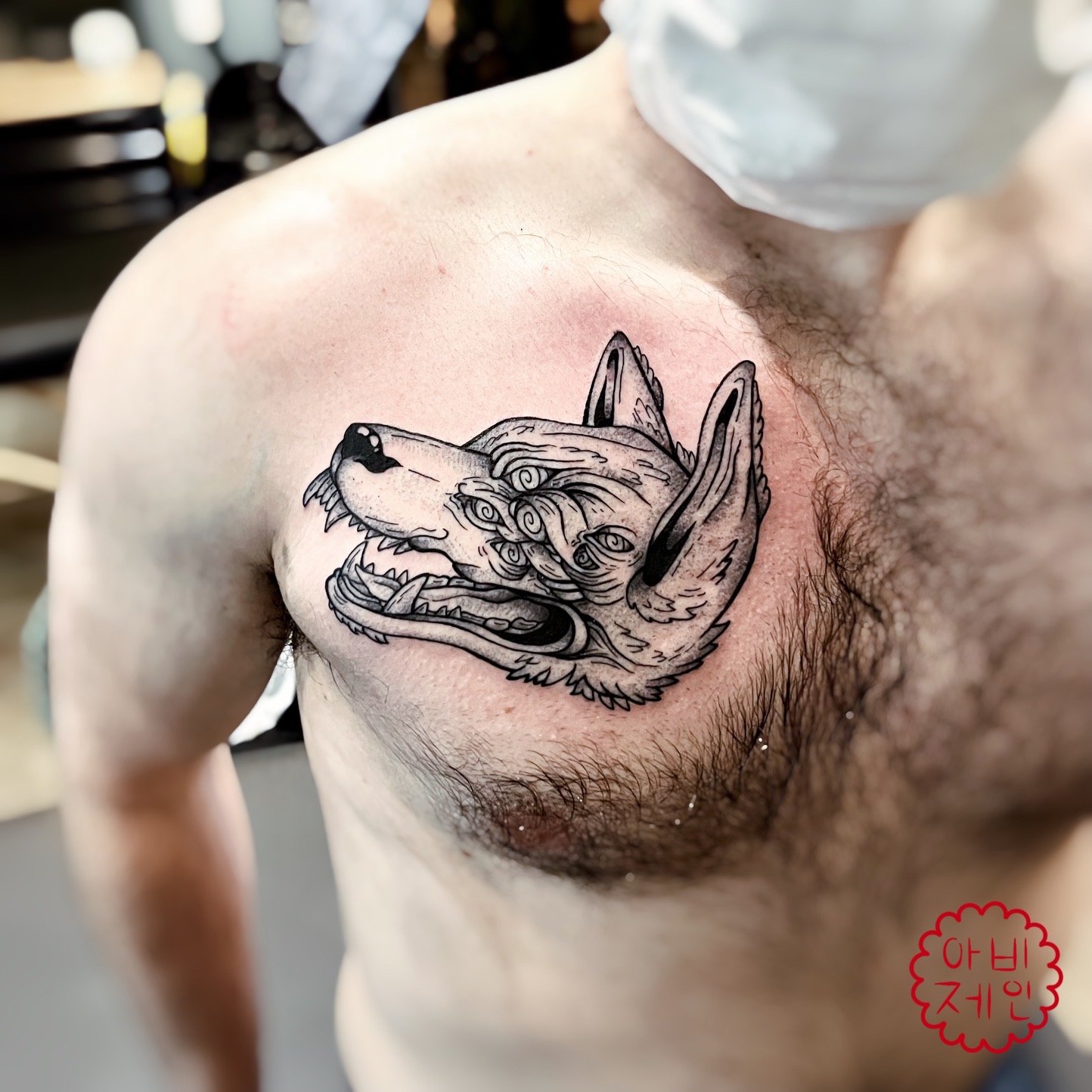 Hypnotic wolf head left chest tattoo.JPEG