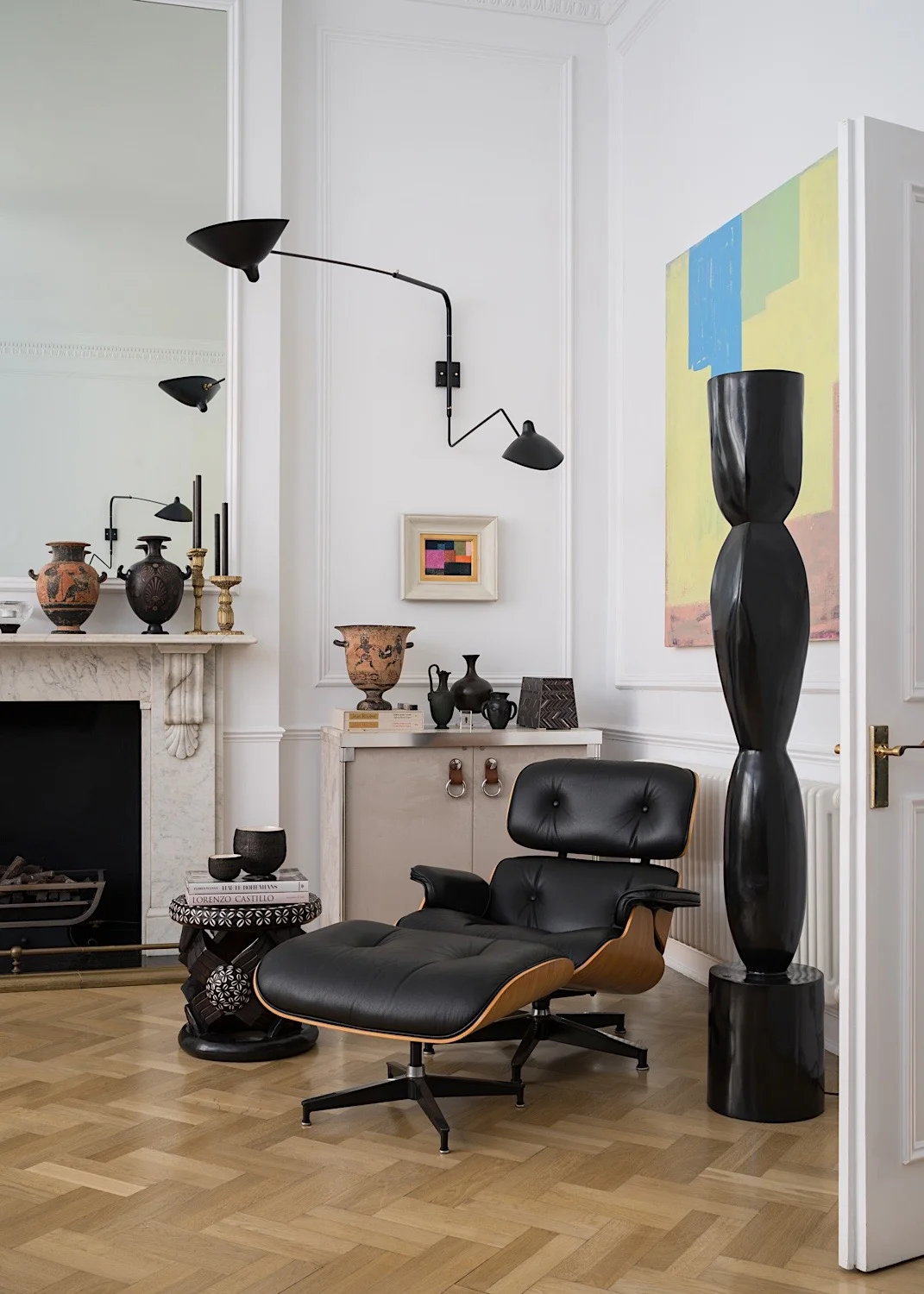 Eames chair & ottoman, Tribal stool, Serge Mouille wall light, bronze torchere by Alexander Lamont. Painting by Joseph Goody.