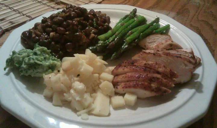 A simple family meal. Chicken Fajitas, black beans, sauteed asparagus, guacamole, and cheddar cheese.