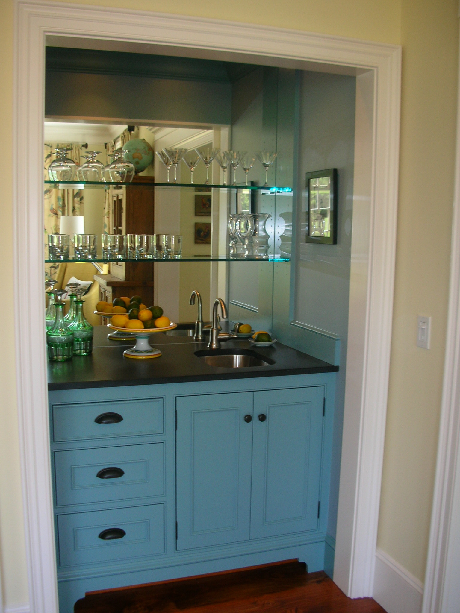 This built in wet bar has lots of storage. Another plus is the mirrored back wall. It helps reflect light in the space.