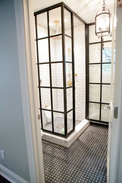 Love this small bathroom. The shower is all glass but the steel frame makes it look vintage and industrial. The black basket weave tile looks great next to the marble subway tile.