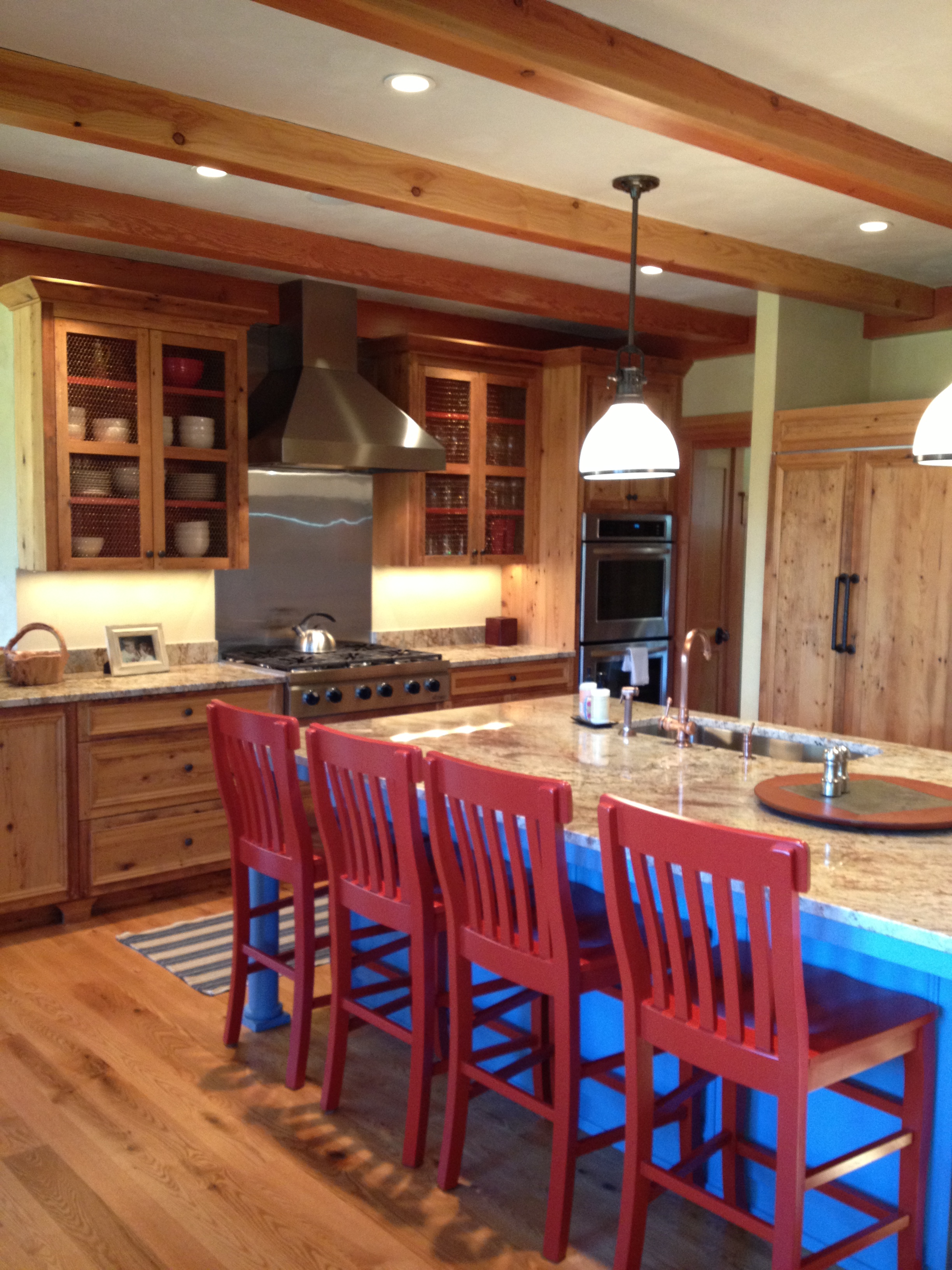 This island adds a pop of color in a kitchen with natural wood cabinets.