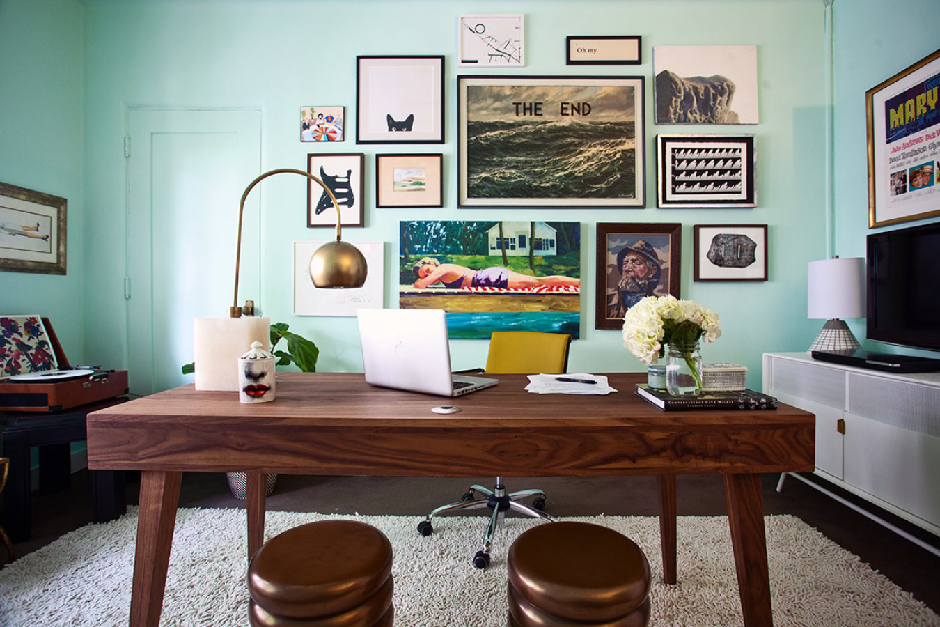 This gallery wall is perfectly playful and smart. Even the aqua wall in this home office provides the perfect backdrop for an irreverent art collection
