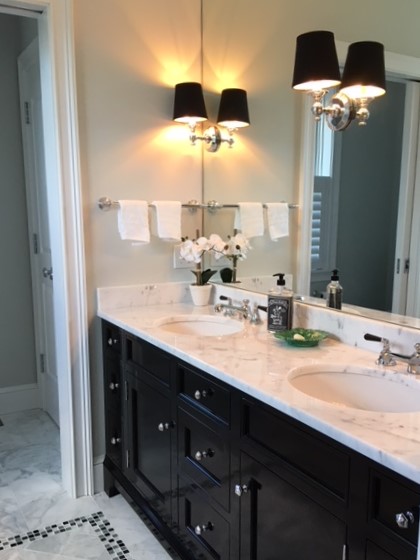 This is one of our favorites...wall to wall mirror glass, double sinks, marble top, lever handle faucets and high gloss vanity!