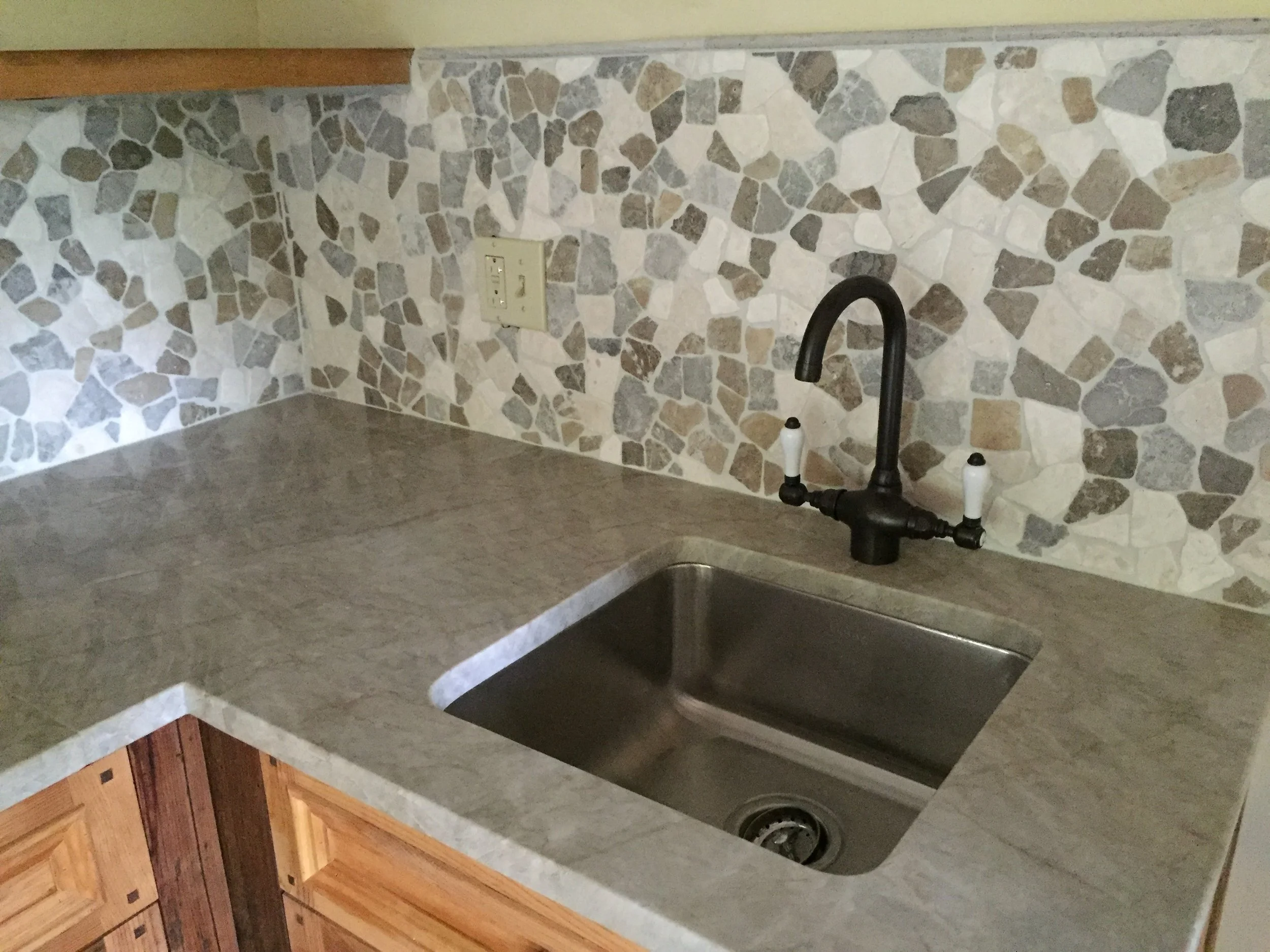 Here is a broader view of the picture above. This small kitchen is in a post and beam guest house. There are a lot of natural elements in the space and we wanted that to hold true for the kitchen. The natural stone top and back splash are a perfect complement to the rest of the guest house.